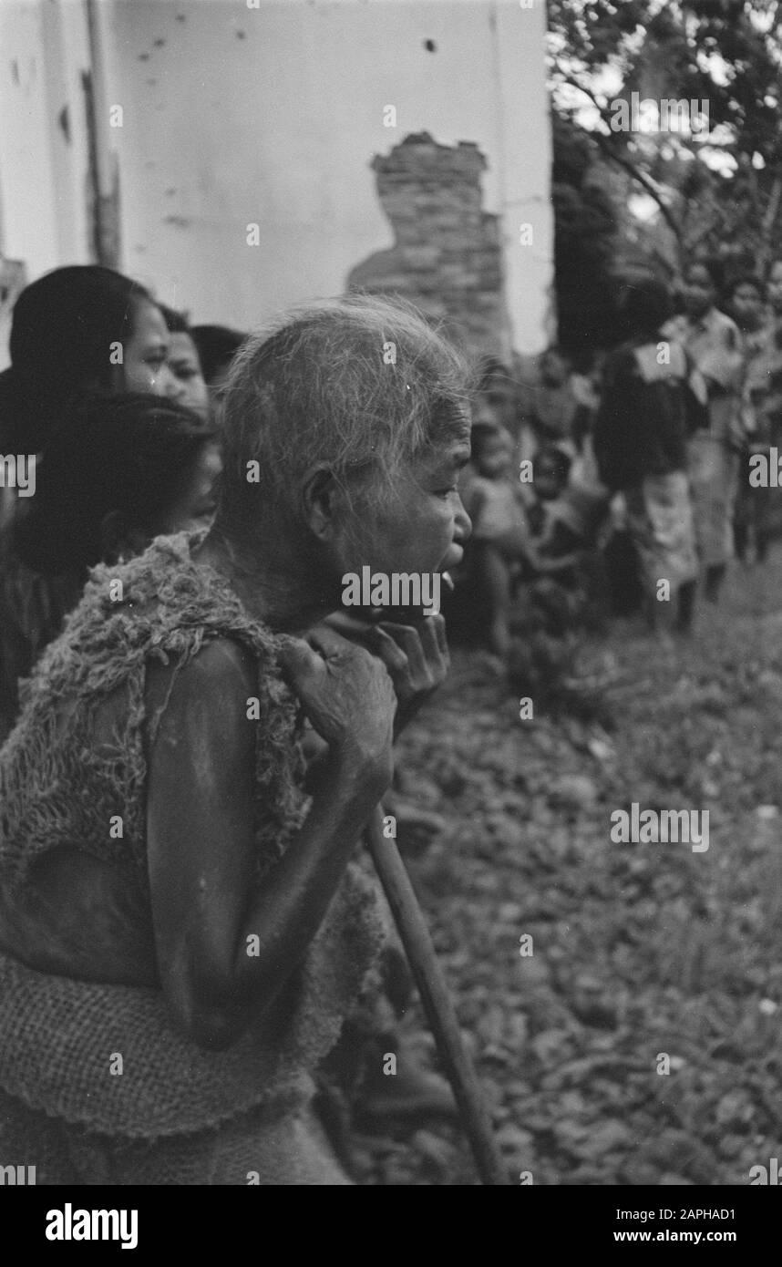 Distribuzione abbigliamento Croce Rossa cura e recupero amministrazione campong a Banjoe-Biroe Descrizione: La popolazione evacuata di Banjoe Biroe (settore Semarang) ritornò all'arrivo delle truppe olandesi presto di nuovo in questa città. Tuttavia, la loro condizione era pietosa, e immediatamente la Croce Rossa ha consegnato cibo e vestiti, mentre i malati sono stati trattati in una policlinica. Data: 11 Novembre 1947 Luogo: Indonesia, Indie Orientali Olandesi Foto Stock