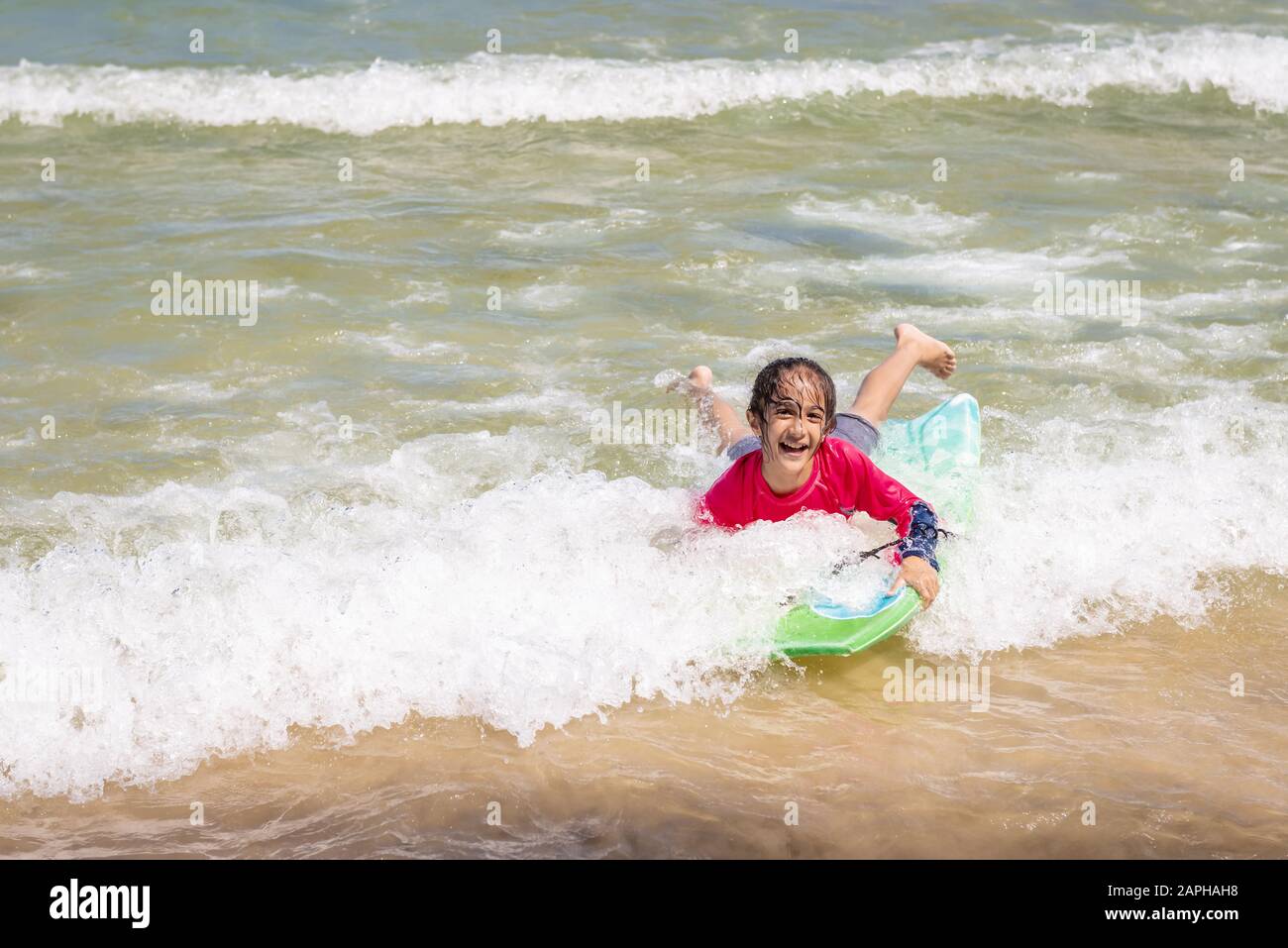 Bambina nuoto in Maracas Bay Beach di Trinidad e Tobago divertendosi spruzzi delle onde Foto Stock
