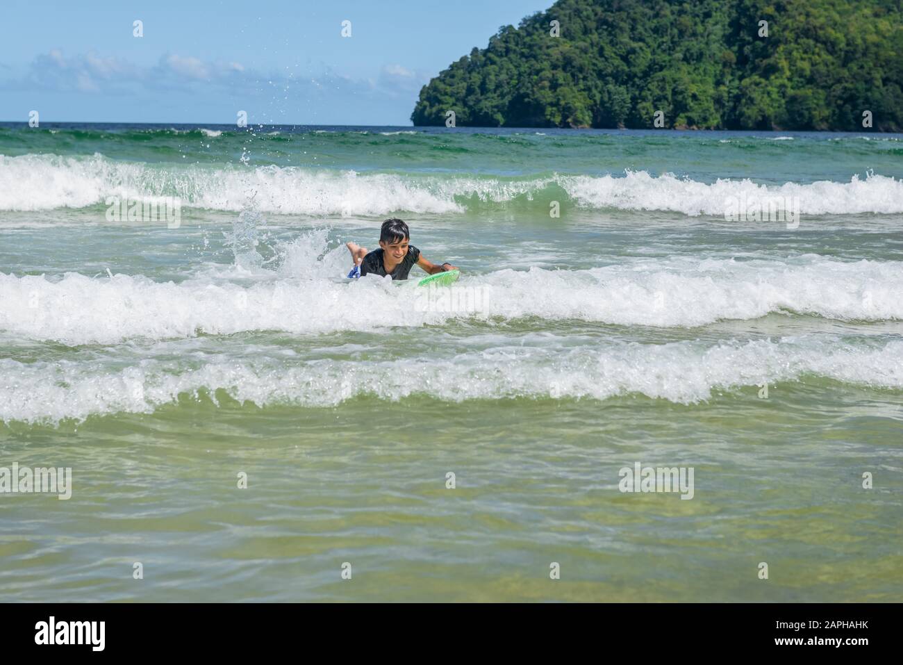Ragazzo più anziano che nuotava a Maracas Bay Beach Trinidad e Tobago con divertenti onde di equitazione Foto Stock