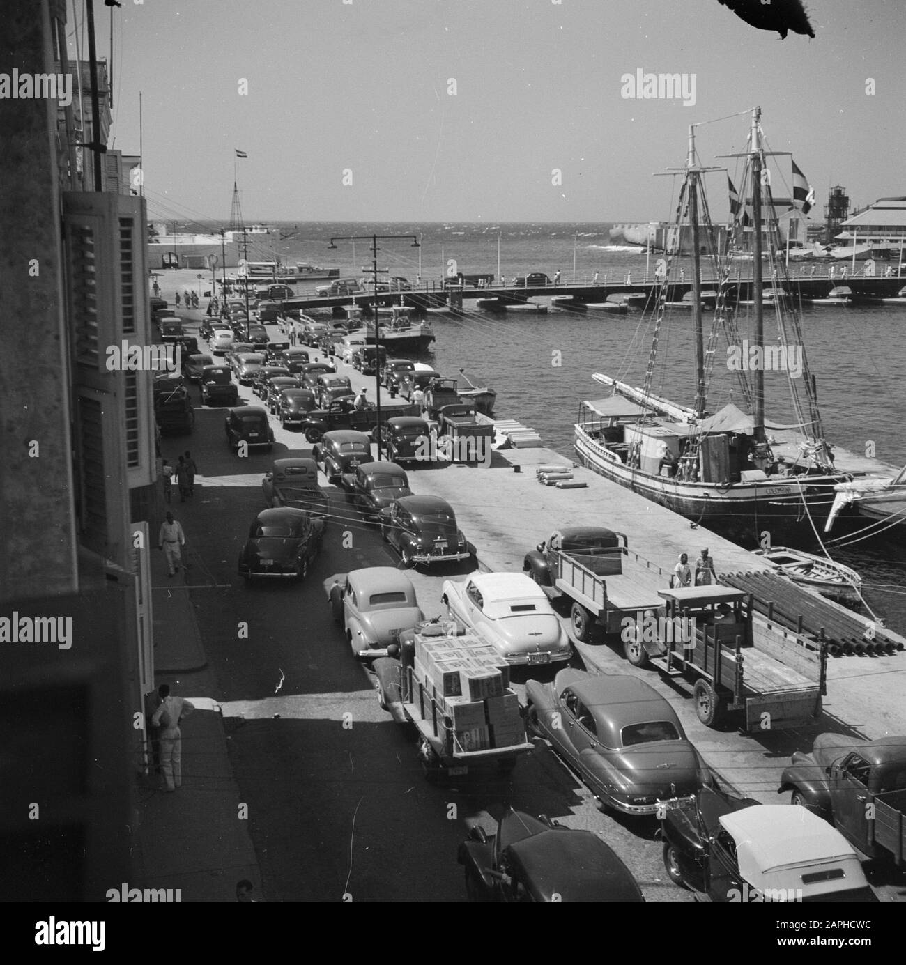 Viaggi in Suriname e Antille Olandesi Descrizione: De Handelskade a Willemstad su Curaçao con auto e navi Data: 1947 Località: Curaçao, Willemstad Parole Chiave: Automobili, navi Nome dell'istituto: Emmabrug Foto Stock