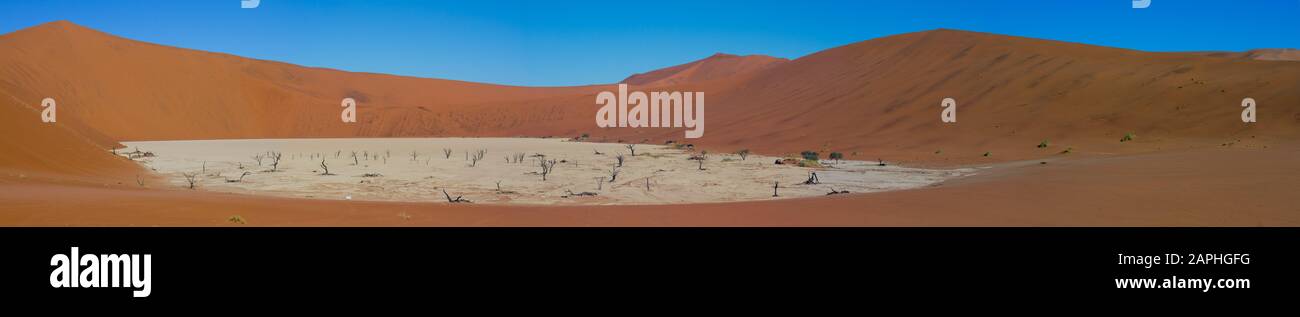 Vista panoramica che mostra il paesaggio delle dune di sabbia rossa di Sossusvlei e gli alberi morti di Deadvlei a Sossusvlei, Namibia Foto Stock