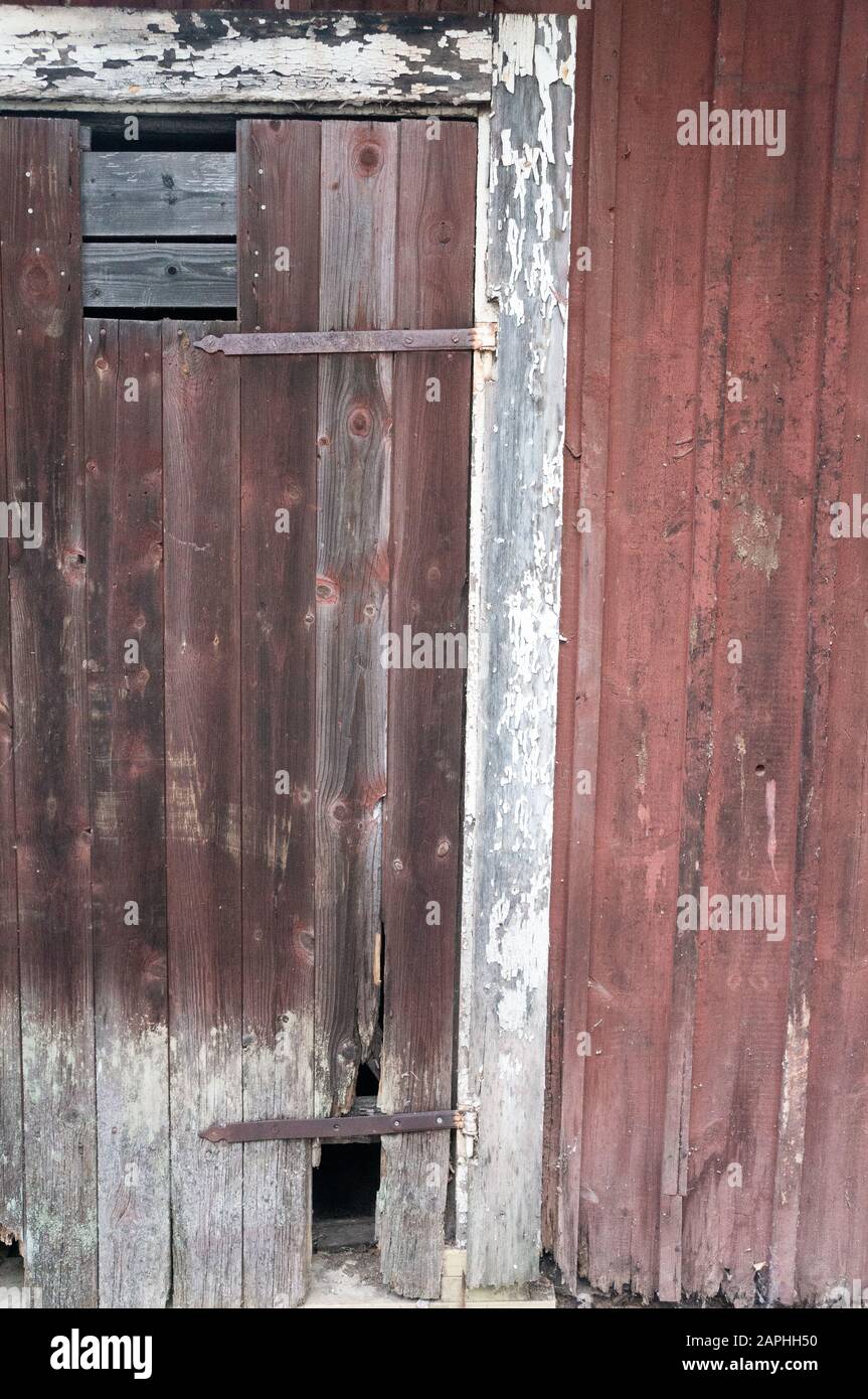 Vernice bianca chipping del legno intorno alla porta e perdere vernice rossa fromt lui fondo Foto Stock