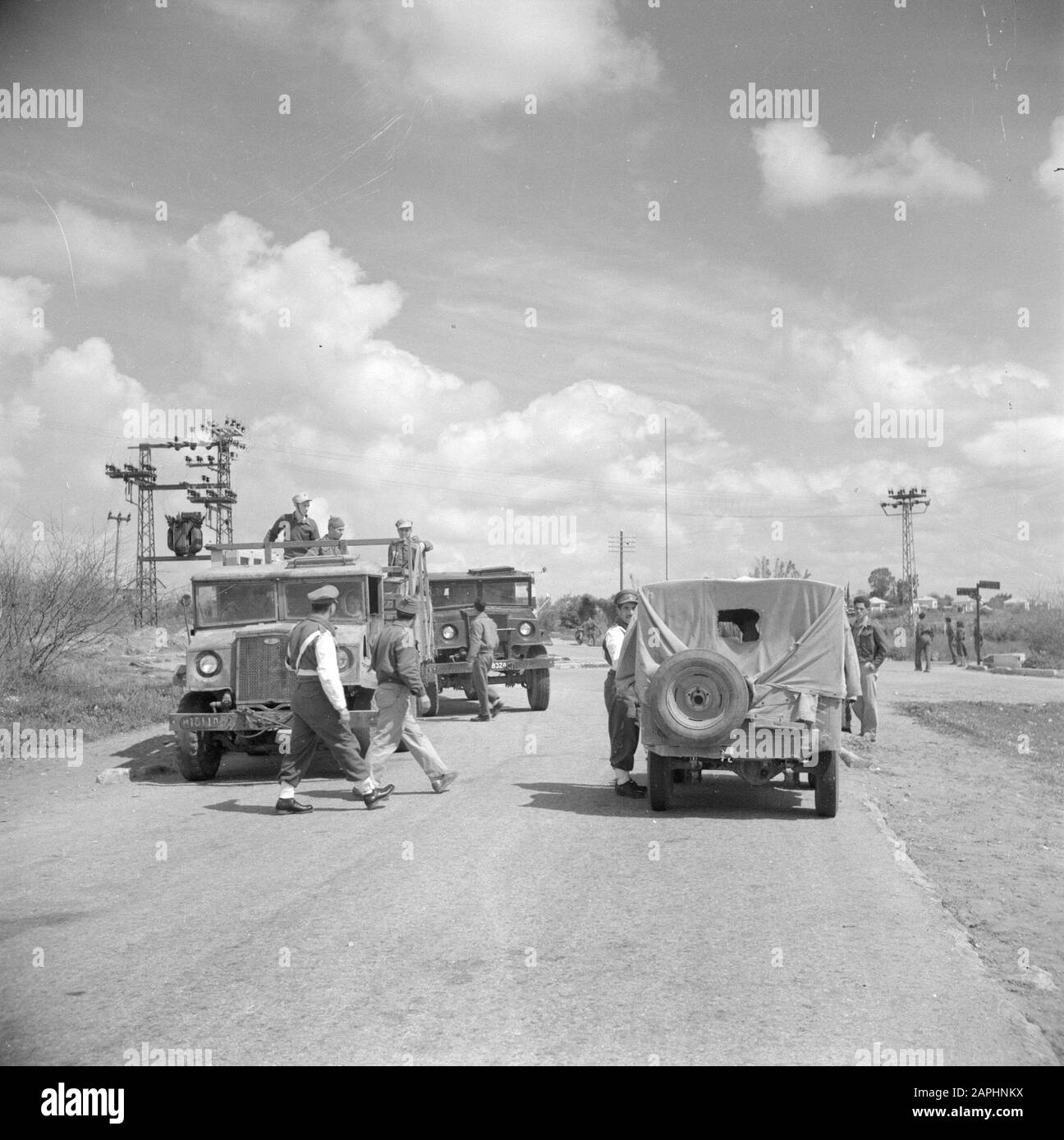 Israele 1948-1949 Descrizione: Polizia militare prendere hitchhikers lungo la strada Data: 1948 posizione: Israele Parole Chiave: Controlli, alberi ad alta tensione, jeep, hitchhikers, polizia militare, uniformi, camion Foto Stock