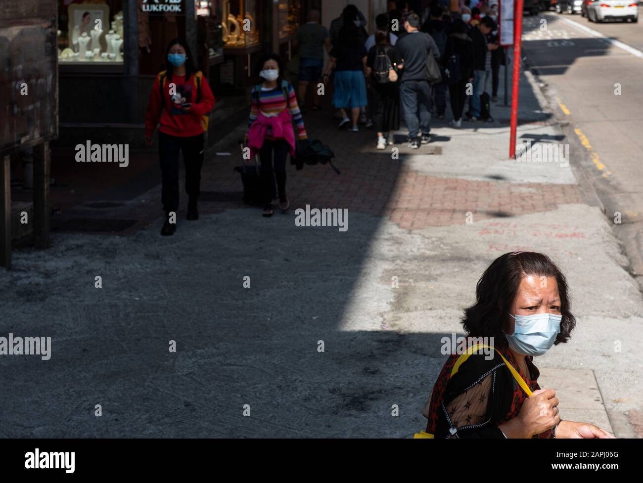 Una donna coprire il suo viso con una maschera sanitaria come lei attende alla stazione degli autobus dopo che i primi casi di coronavirus sono stati confermati a Hong Kong. La Cina ha implementato un sistema di trasporto pubblico e un blocco aeroportuale in diverse città per rallentare la diffusione del coronavirus di Wuhan. Foto Stock