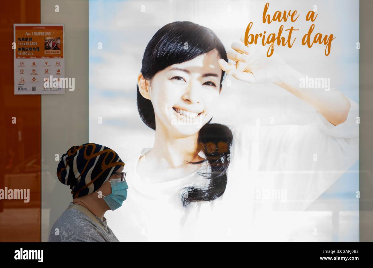 Un pedone copre il suo viso con una maschera sanitaria dopo che i primi casi di coronavirus sono stati confermati a Hong Kong, Cina, il 23 gennaio 2020. La Cina ha implementato un sistema di trasporto pubblico e un blocco aeroportuale in diverse città per rallentare la diffusione del coronavirus di Wuhan. Foto Stock