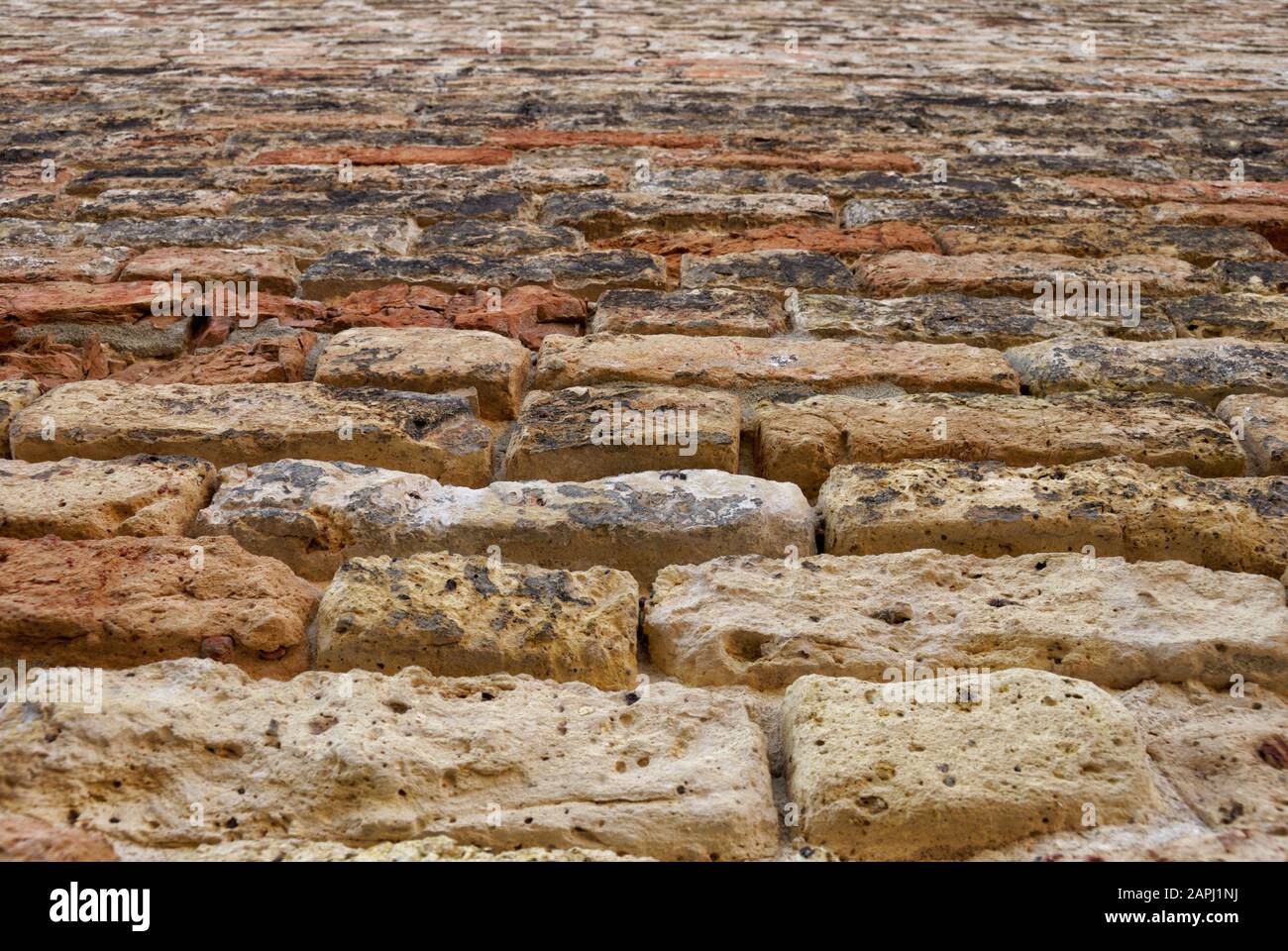 Antico muro di pietra texture con arancio-marrone cast. Foto Stock