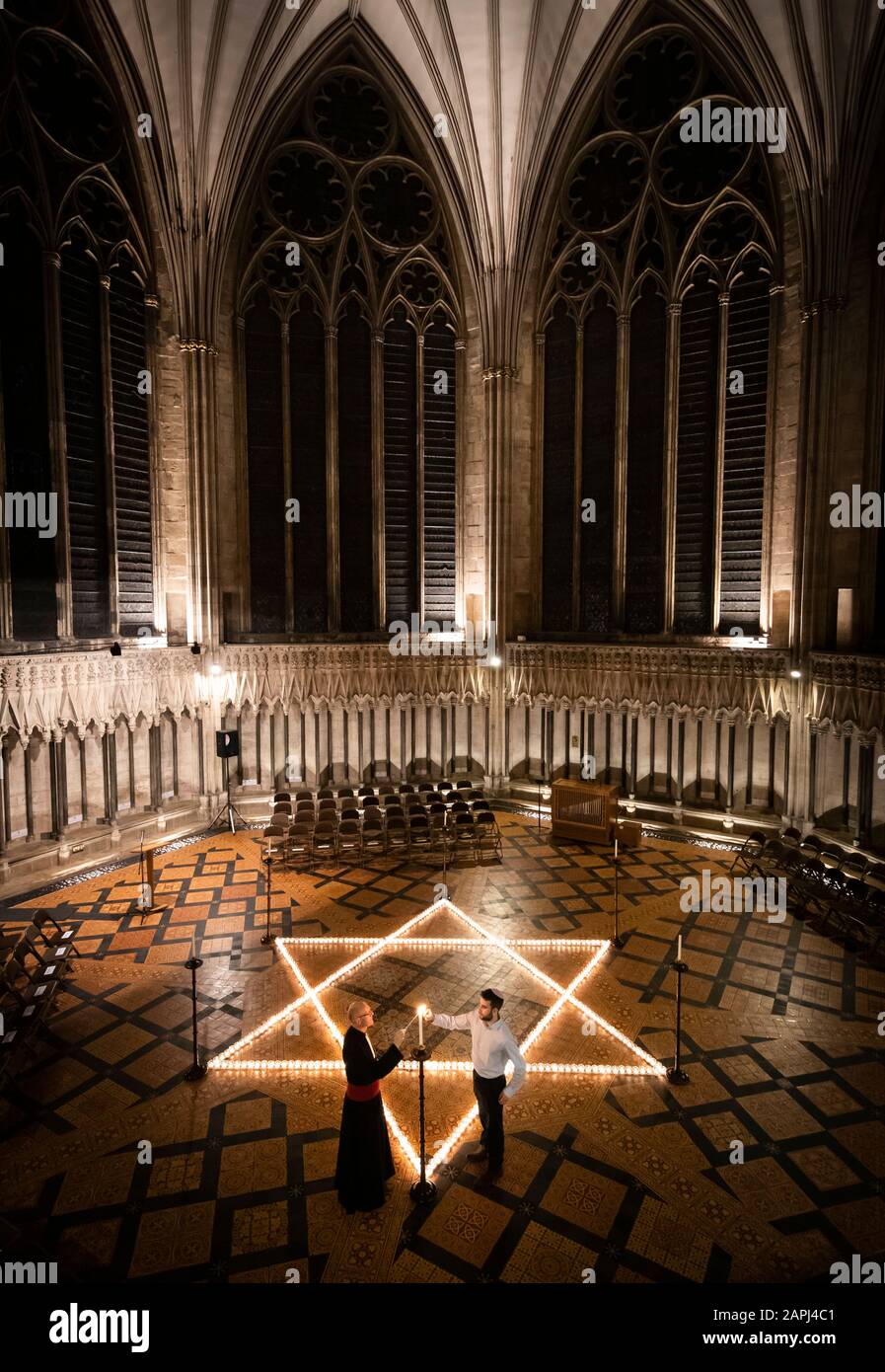 York Minster canonico cancelliere Christopher Collingwood (sinistra) e Joshua Daniels (destra) della York University Jewish Society, aiutano a illuminare seicento candele a forma di Stella di Davide, in memoria di oltre 6 milioni di ebrei assassinati dai nazisti nella seconda guerra mondiale, Nella Chapter House della York Minster di York, parte della commemorazione della York Minster per la Giornata Internazionale dell'Olocausto. Foto Stock