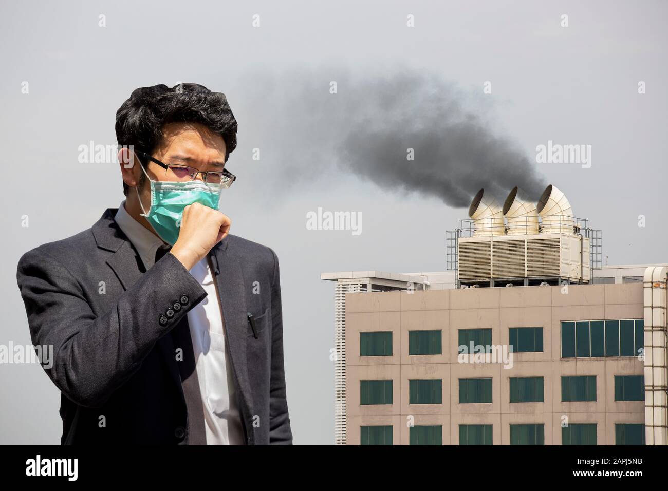 Un uomo che indossa la maschera della bocca contro l'inquinamento da smog d'aria con PM 2.5. Foto Stock