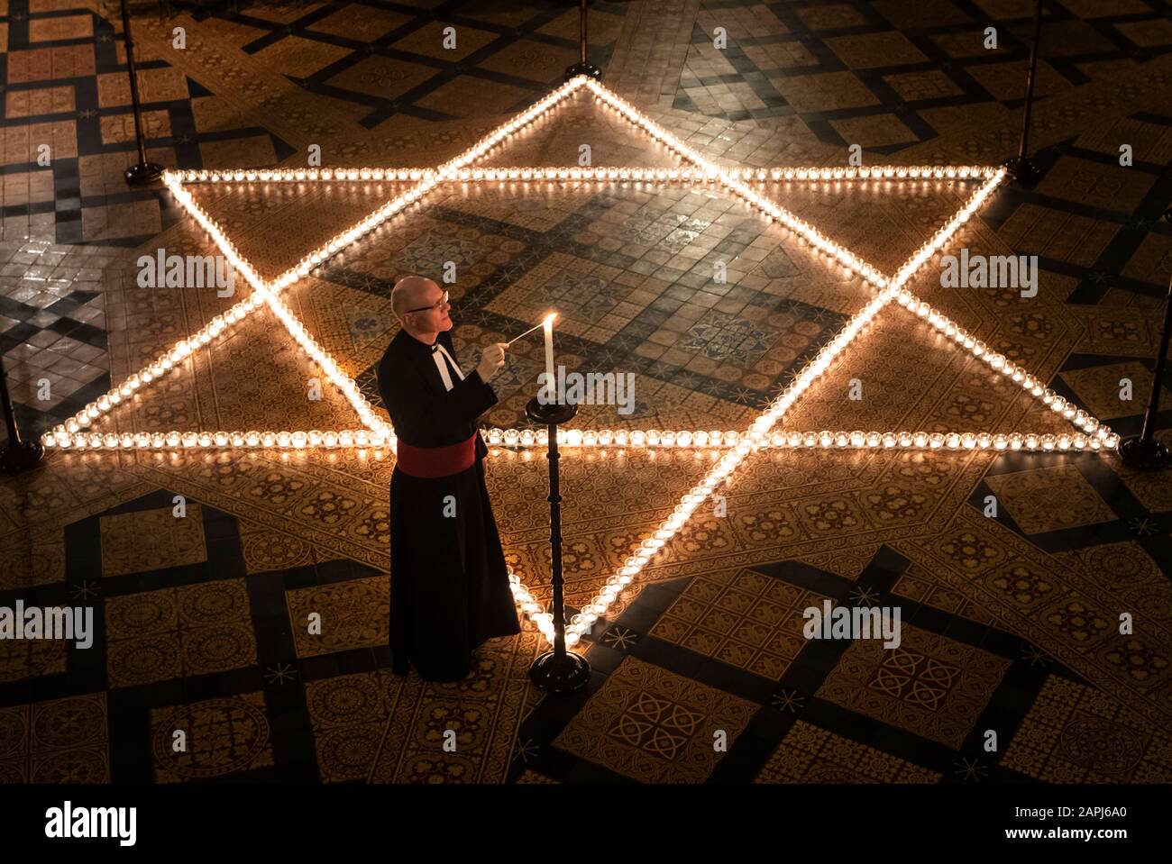 Il canonico cancelliere Christopher Collingwood aiuta a illuminare seicento candele a forma di Stella di Davide, in memoria di oltre 6 milioni di ebrei assassinati dai nazisti nella seconda guerra mondiale, nella Casa capitolare di York Minster a York, Parte della commemorazione della cattedrale di York per la Giornata Internazionale dell'Olocausto. Foto Stock