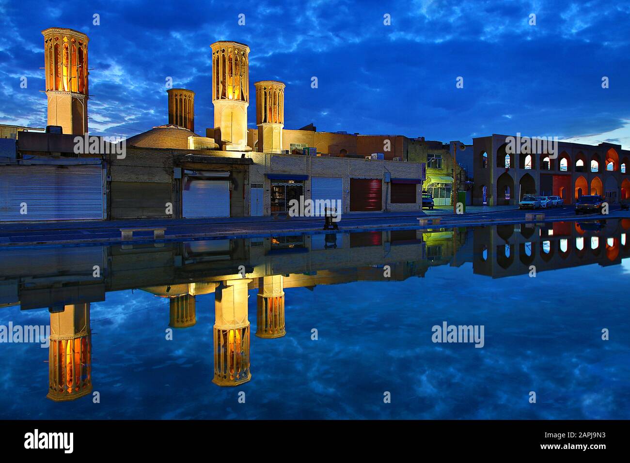 Torri del vento e riflessioni al crepuscolo, nell'antica città di Yazd, Iran Foto Stock