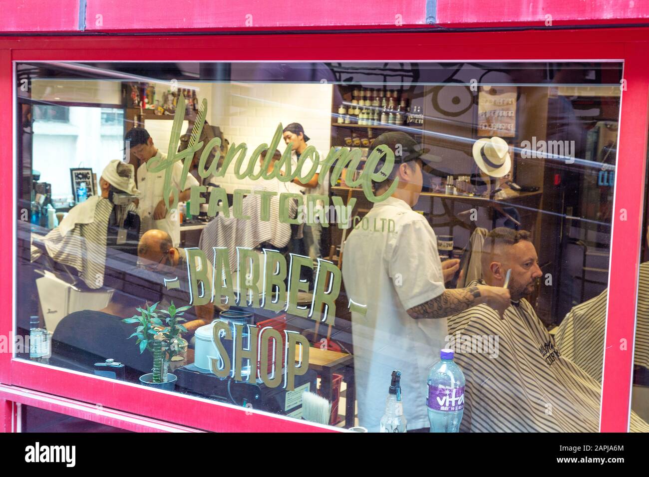 Negozio di barbiere di Hong Kong con barbiere che lavorano i capelli da taglio - vita quotidiana, Hong Kong Asia Foto Stock