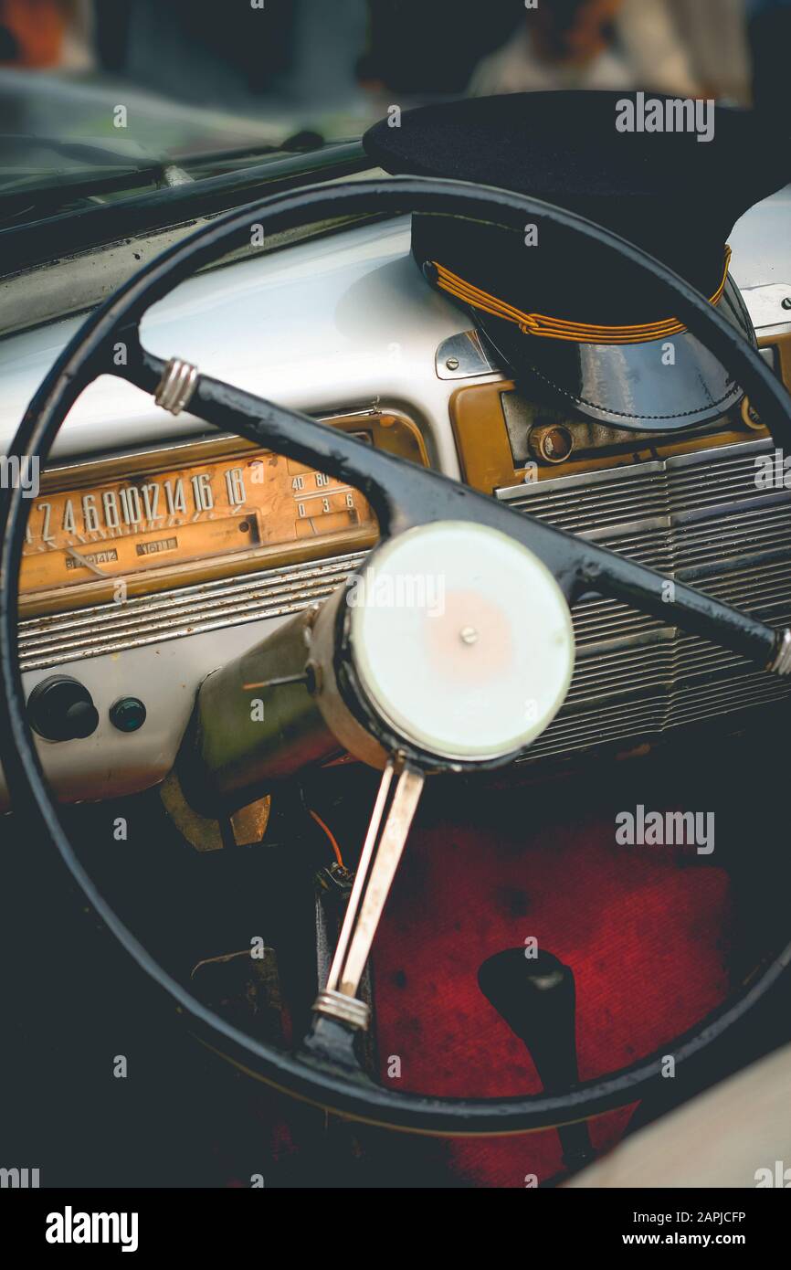 Cruscotto di vecchia auto con il volante e il cappuccio del conducente Foto Stock