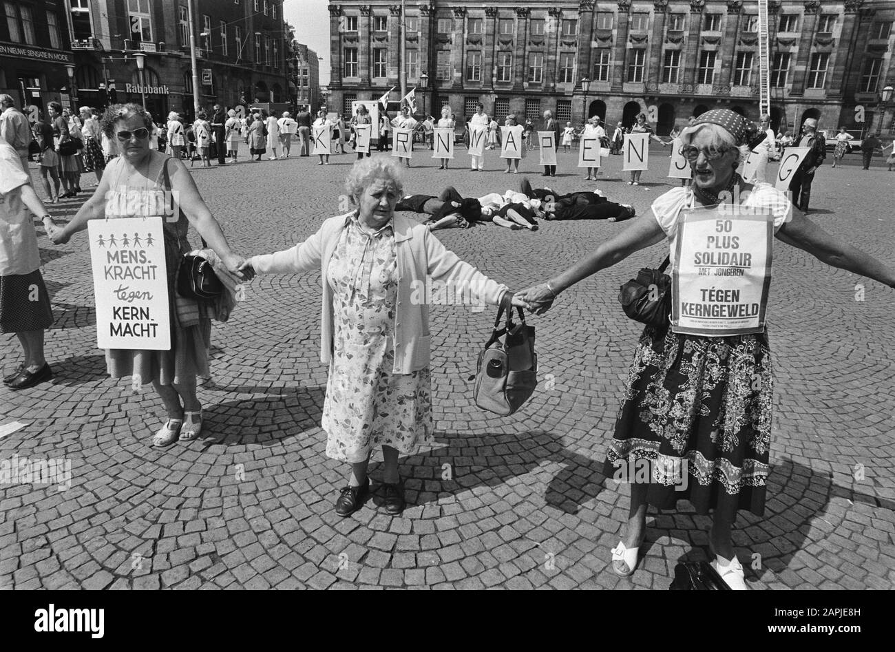 Protesta contro le armi nucleari ogni primo lunedì del mese a Piazza Dam di Amsterdam Descrizione: I manifestanti con bandiere formano un cerchio intorno alle vittime delle armi nucleari Data: 4 luglio 1983 luogo: Amsterdam, North Holland Parole Chiave: Azioni, movimento anti-armi nucleari Foto Stock