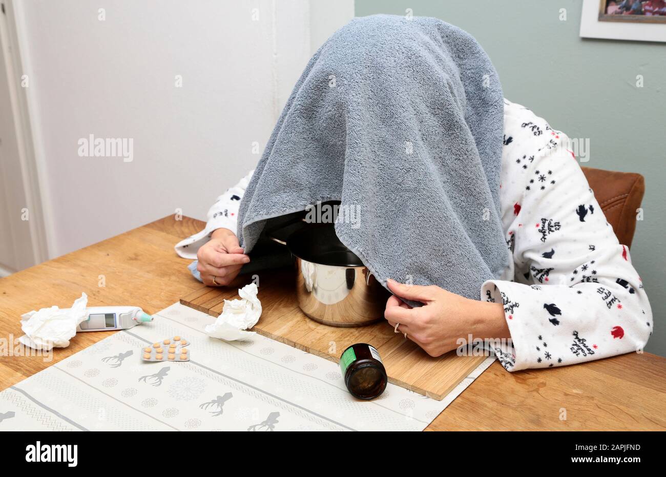 Una donna prende un bagno di vapore a causa dell'influenza Foto Stock