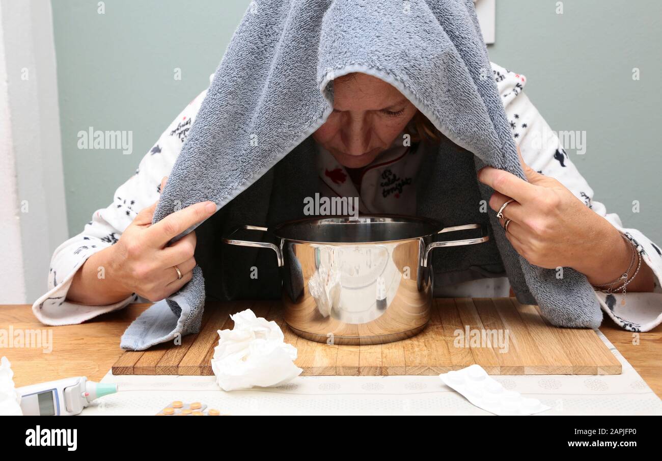 Una donna prende un bagno di vapore a causa dell'influenza Foto Stock