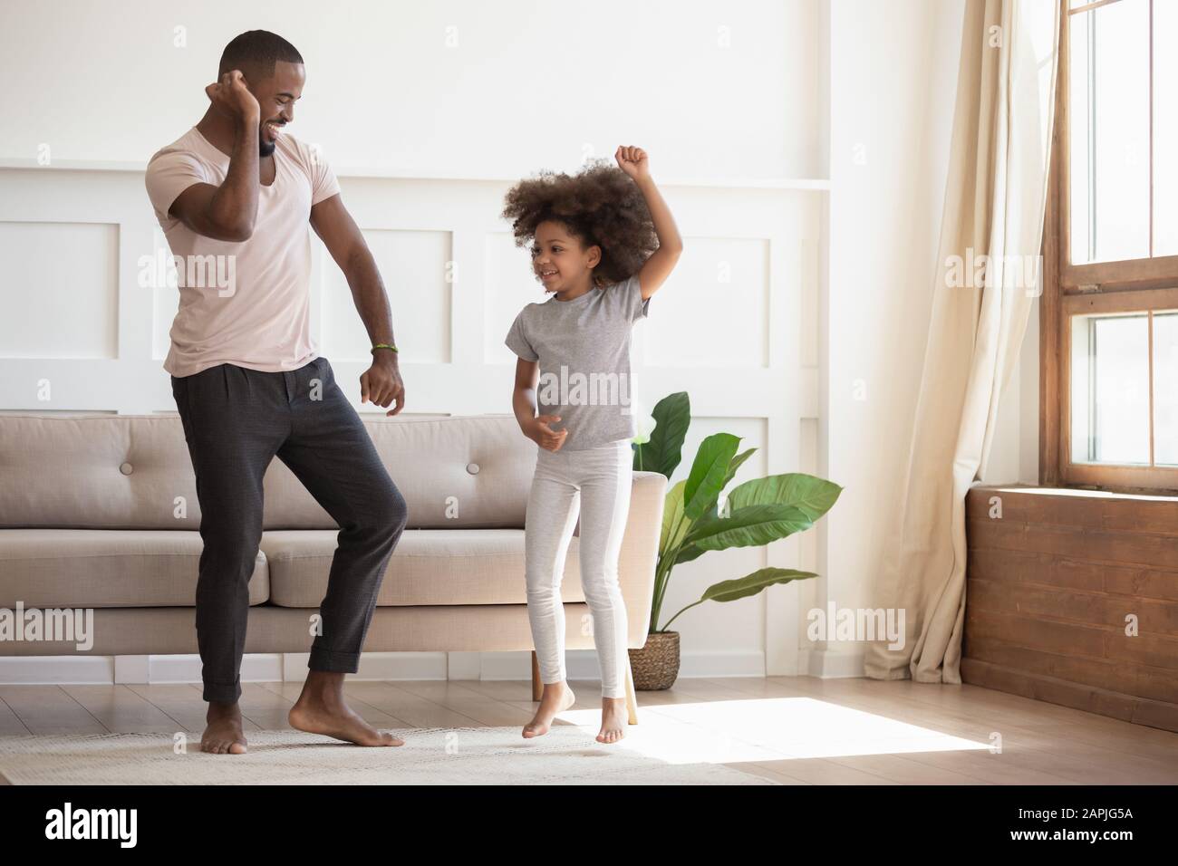 In soggiorno padre africano che balla con figliola Foto Stock