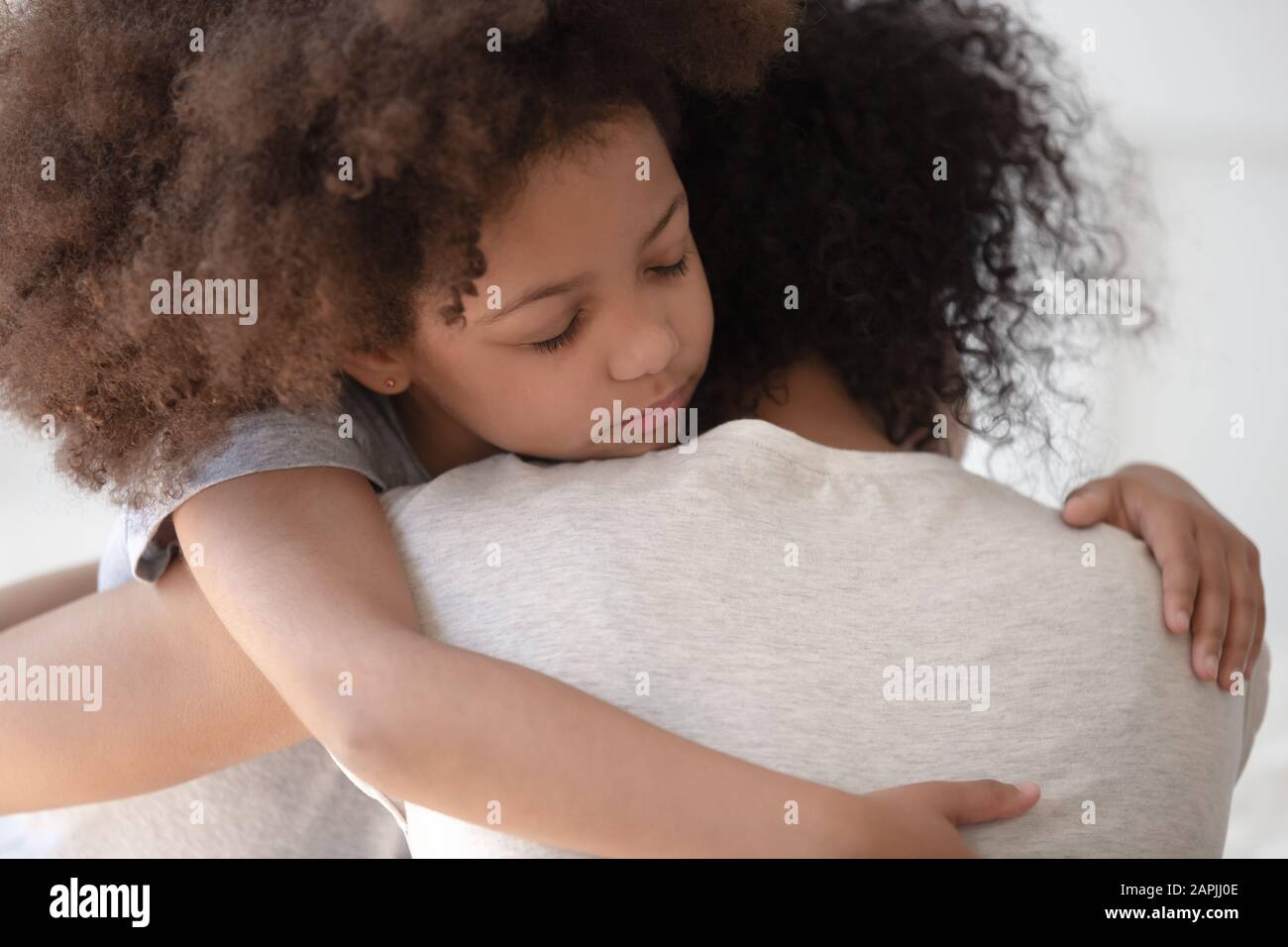 La figlia africana abbraccia la vista posteriore posteriore posteriore della madre del closeup Foto Stock