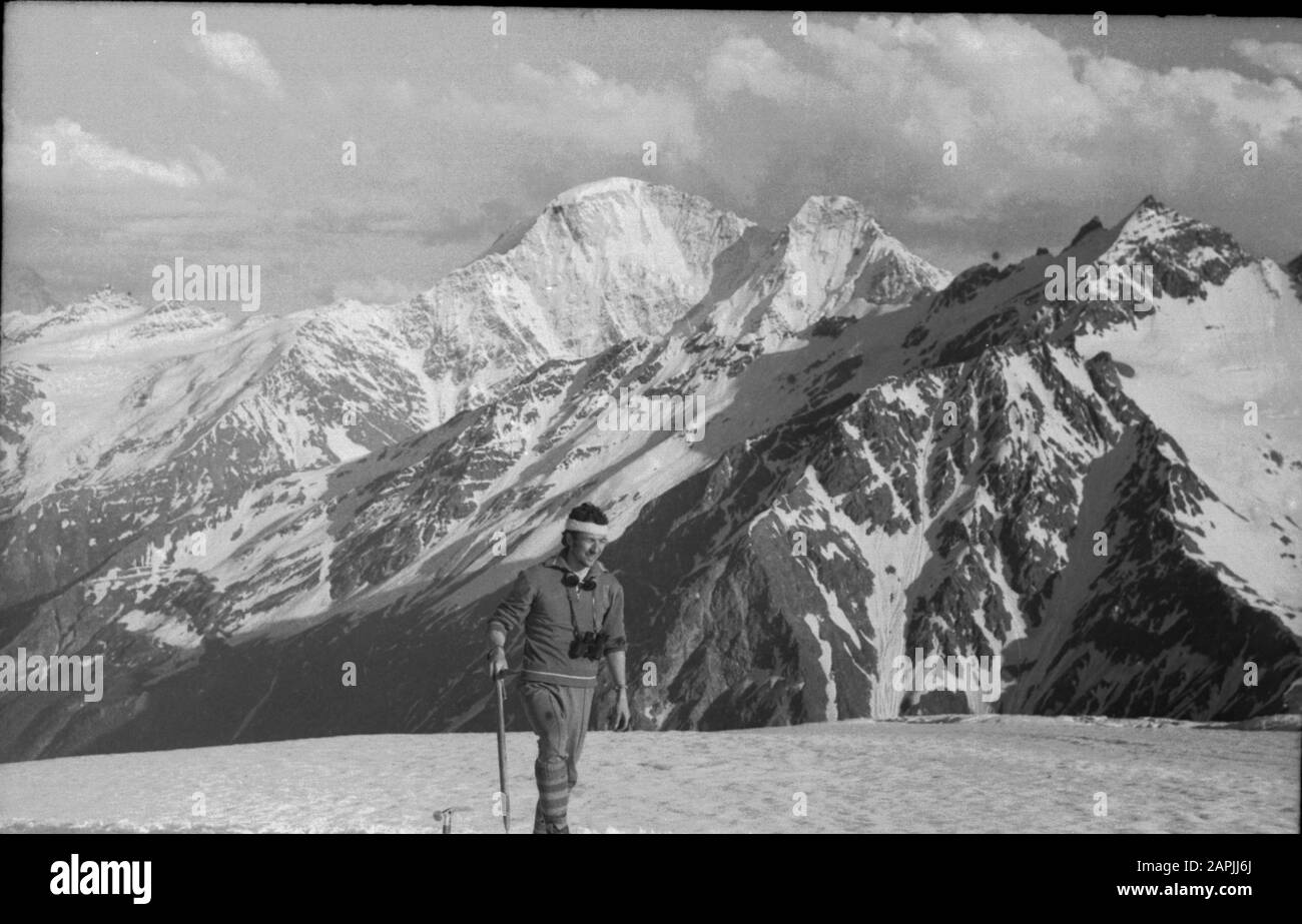 L'alpinista sovietico su una fermata si erge su uno sfondo di montagne con una piccozza di ghiaccio e binocolo. Montagne del Caucaso 70s Foto Stock