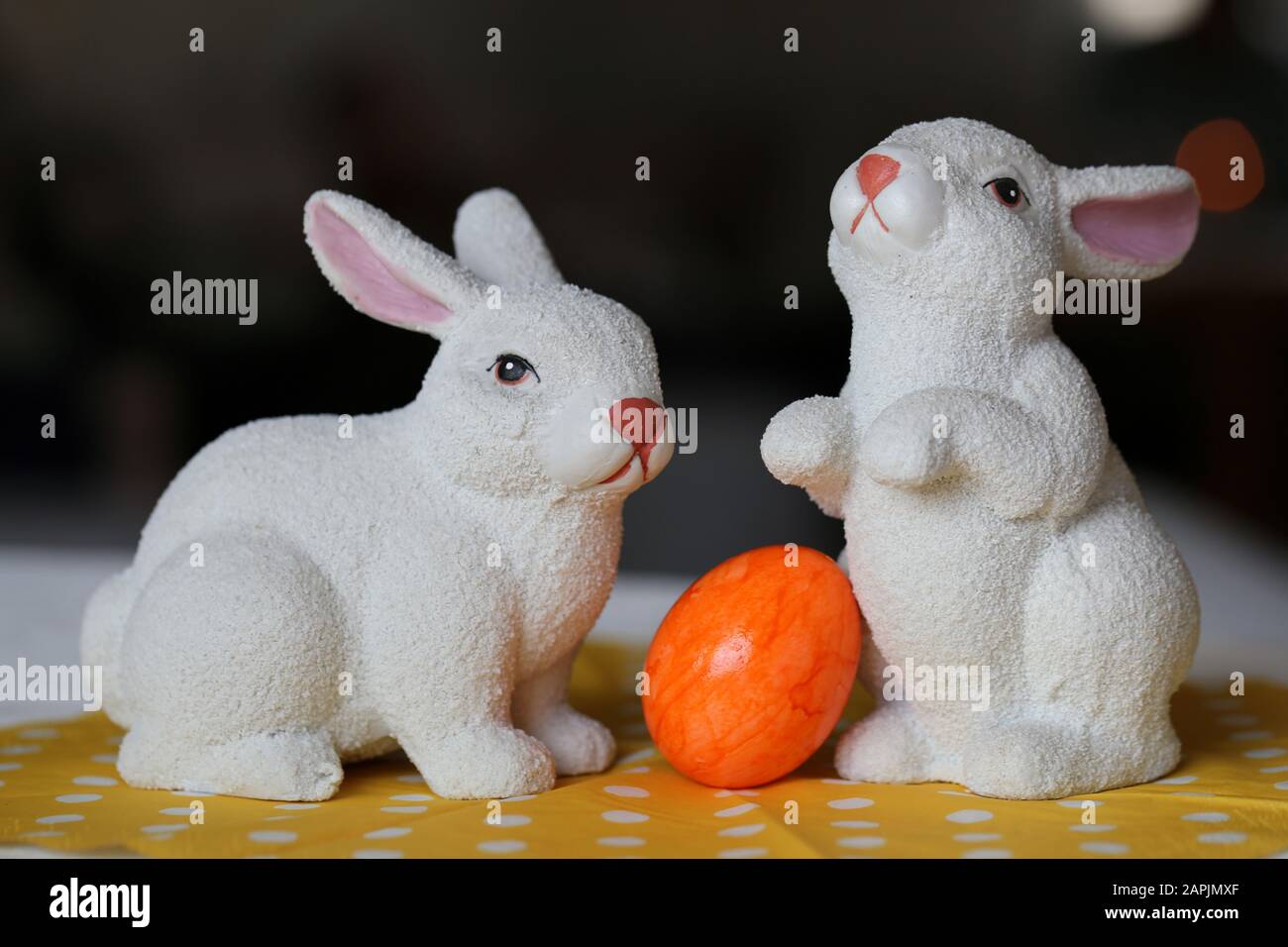 Decorazioni pasquali colorate e gioiose su un tavolo. Immagine a colori closeup di due coniglietti di Pasqua in ceramica e colorate uova di Pasqua dipinte. Foto Stock