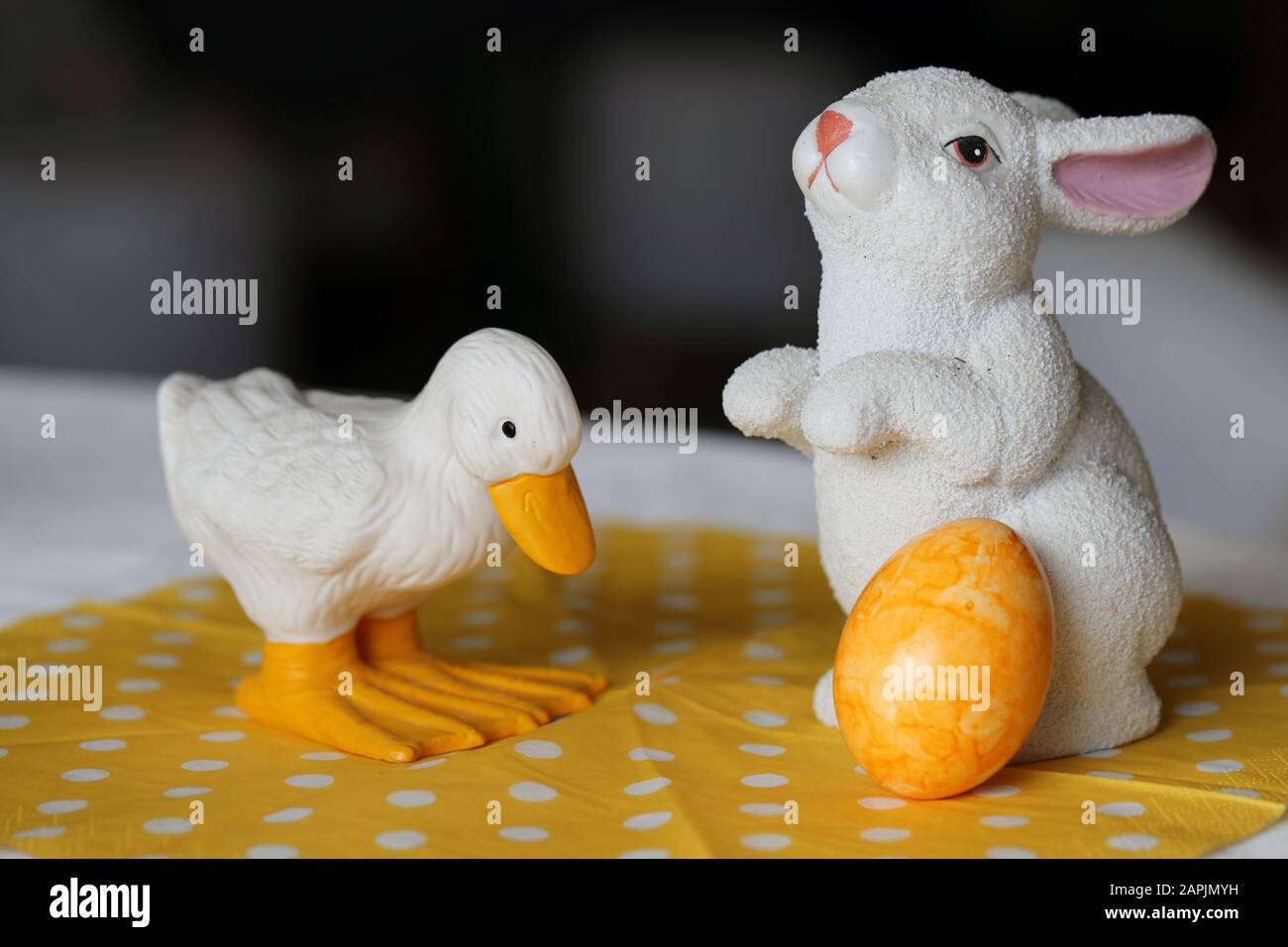 Colorate decorazioni pasquali su un tavolo. Immagine a colori closeup di una ceramica bianca coniglietto di Pasqua e anatra figure e colorate uova di Pasqua dipinte. Foto Stock