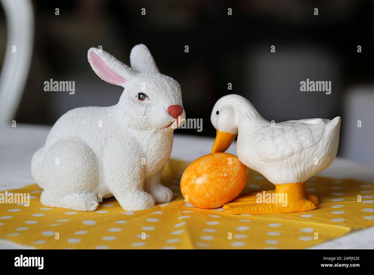 Colorate decorazioni pasquali su un tavolo. Immagine a colori closeup di una ceramica bianca coniglietto di Pasqua e anatra figure e colorate uova di Pasqua dipinte. Foto Stock