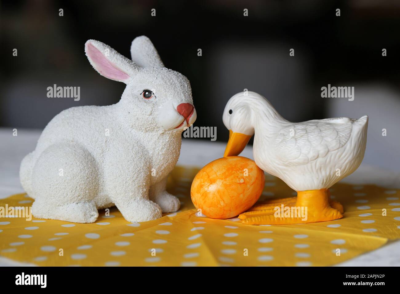 Colorate decorazioni pasquali su un tavolo. Immagine a colori closeup di una ceramica bianca coniglietto di Pasqua e anatra figure e colorate uova di Pasqua dipinte. Foto Stock