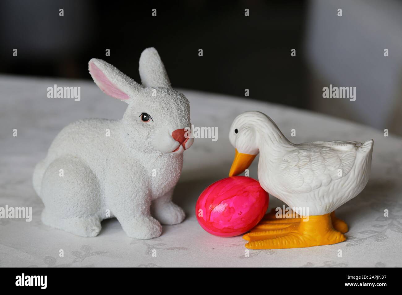 Colorate decorazioni pasquali su un tavolo. Immagine a colori closeup di una ceramica bianca coniglietto di Pasqua e anatra figure e colorate uova di Pasqua dipinte. Foto Stock