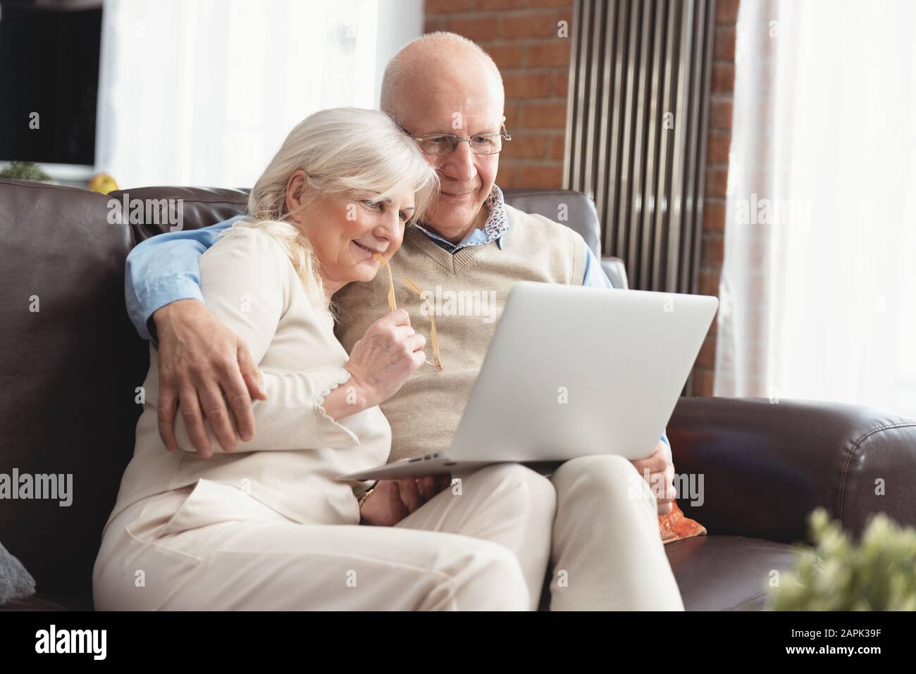 Coppia senior navigando in internet insieme. I pensionati utilizzando un computer portatile a casa Foto Stock