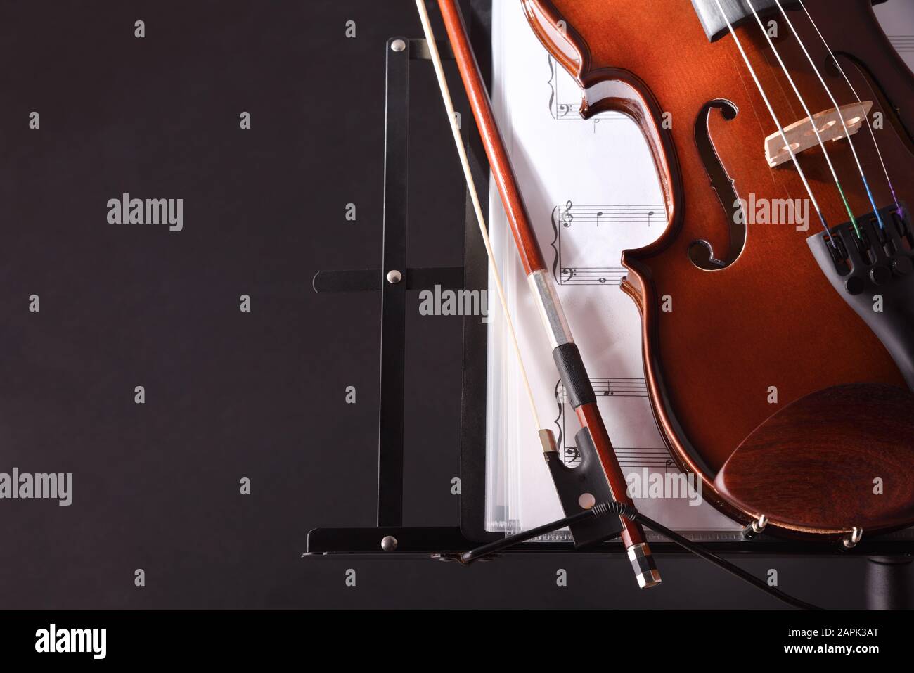 Violino closeup con stand di musica di prua e punteggio sfondo nero. Vista frontale. Composizione orizzontale. Foto Stock