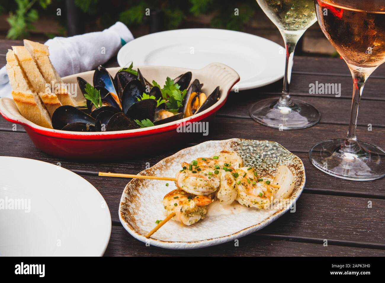 Cozze e antipasti di pollo con due bicchieri di vino Foto Stock