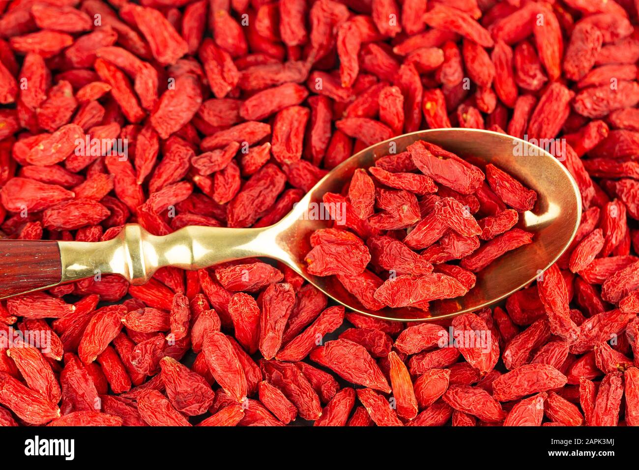 Bacche goji in un cucchiaio d'oro vintage, vista dall'alto. Goji bacche sfondo naturale Foto Stock