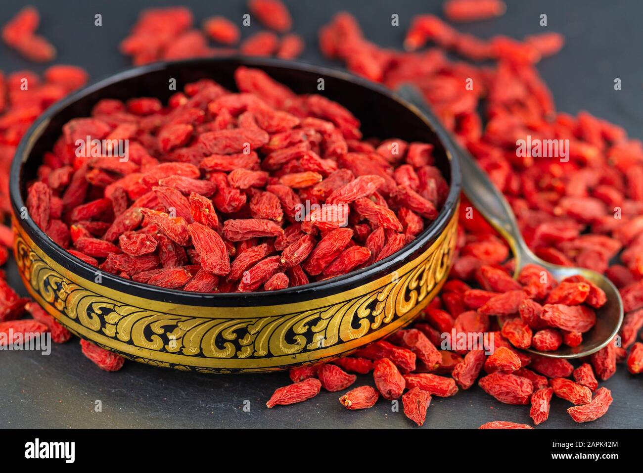 Bacche di goji in tazza d'oro in primo piano. Messa a fuoco selettiva Foto Stock