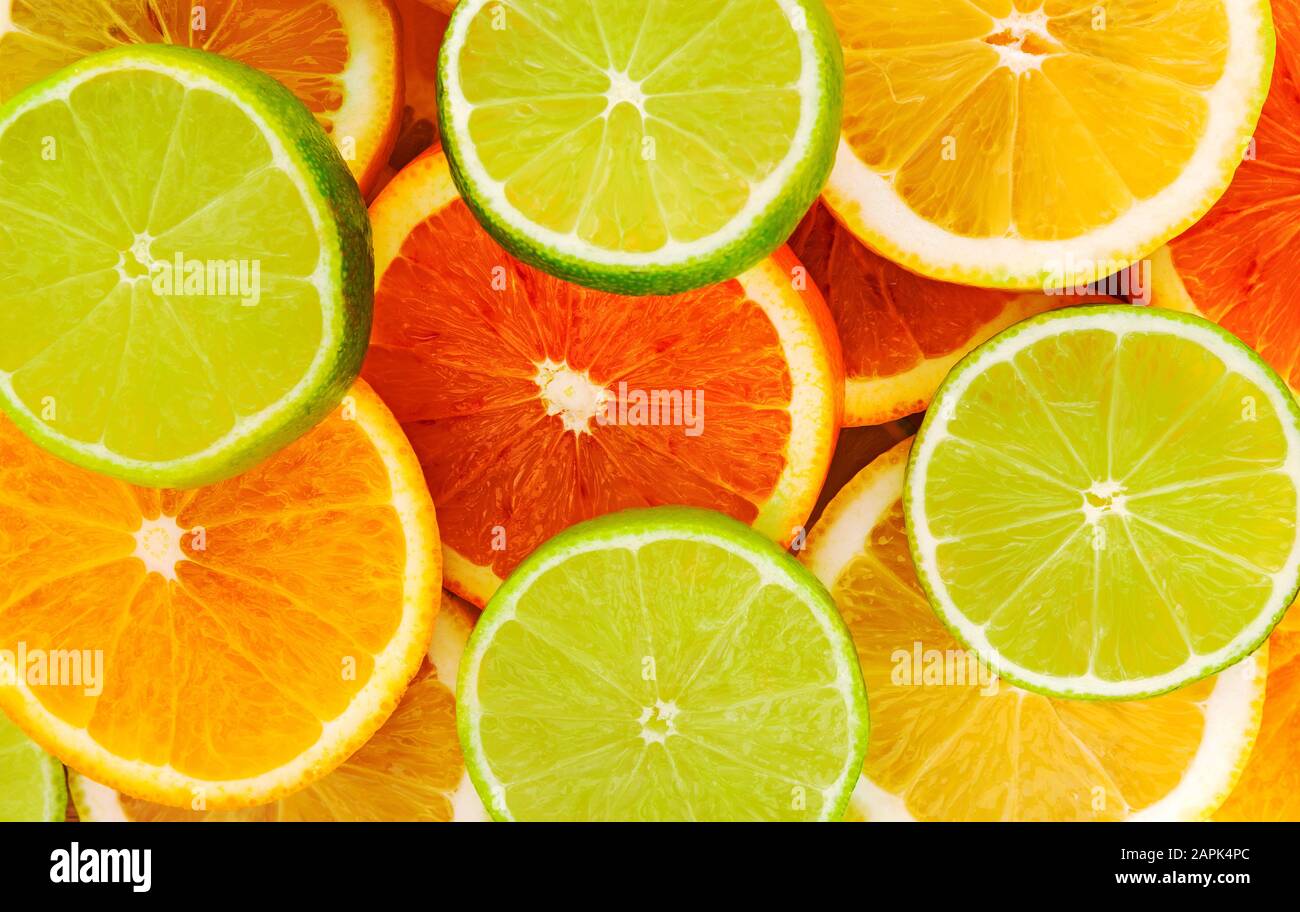 Fetta di agrumi. Fetta succosa di lime, limone, sfondo arancione. Foto Stock