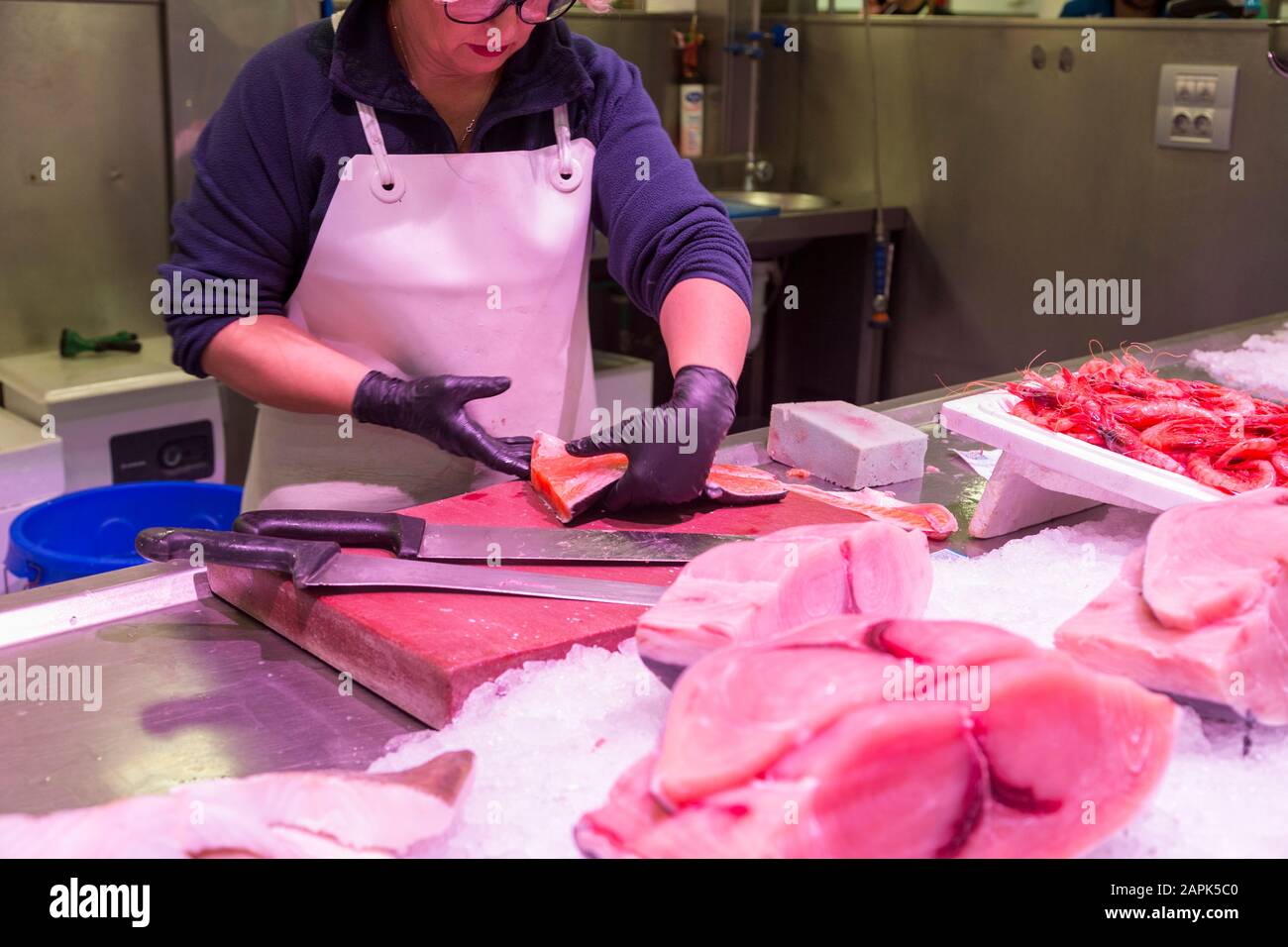 Mercato centrale, pesce di filettatura di pesciveria femminile, taglio di fette di tonno crudo, almeria, spagna Foto Stock