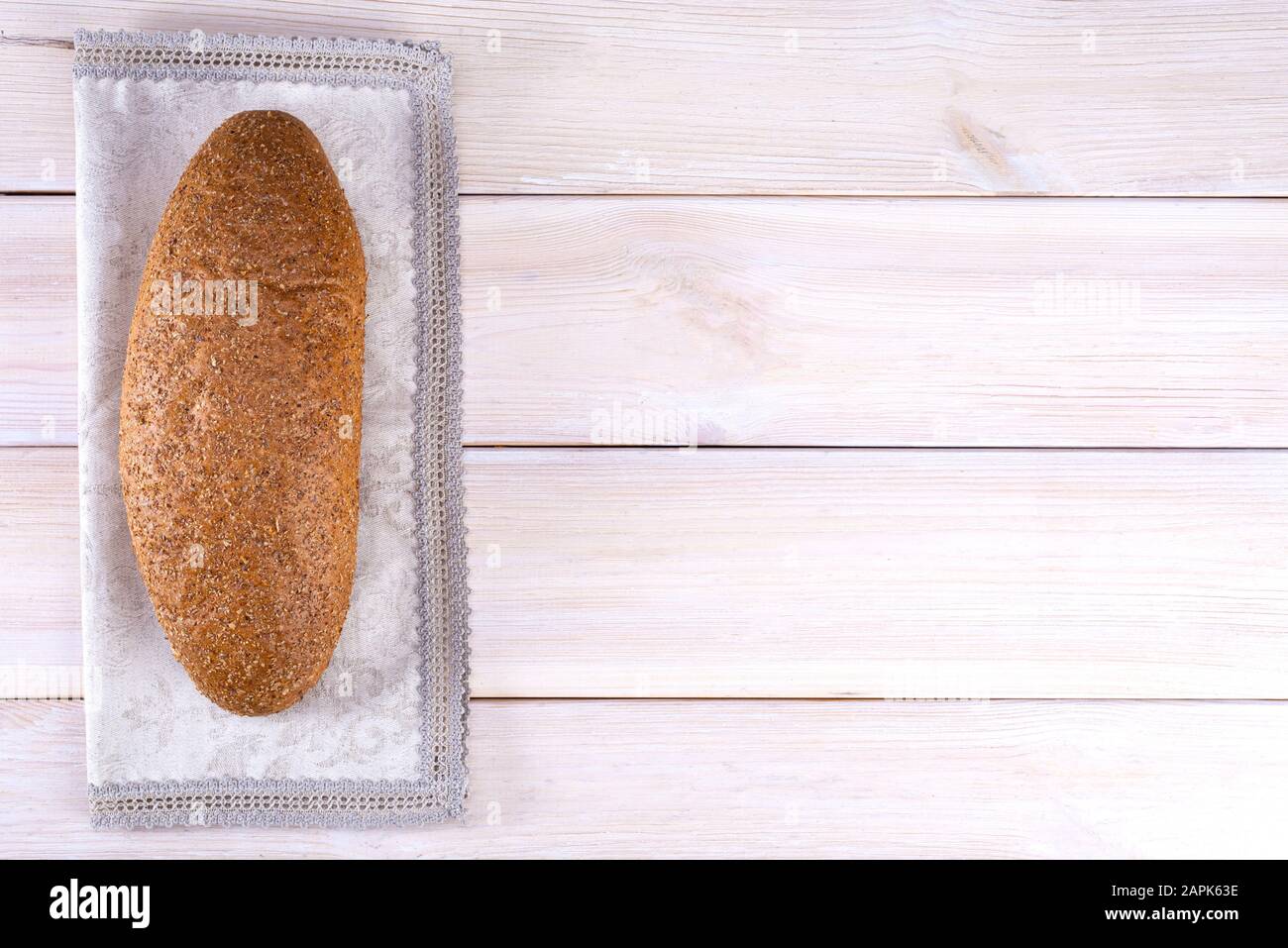Pane con crusca su sfondo di legno chiaro con posto per testo, vista dall'alto Foto Stock