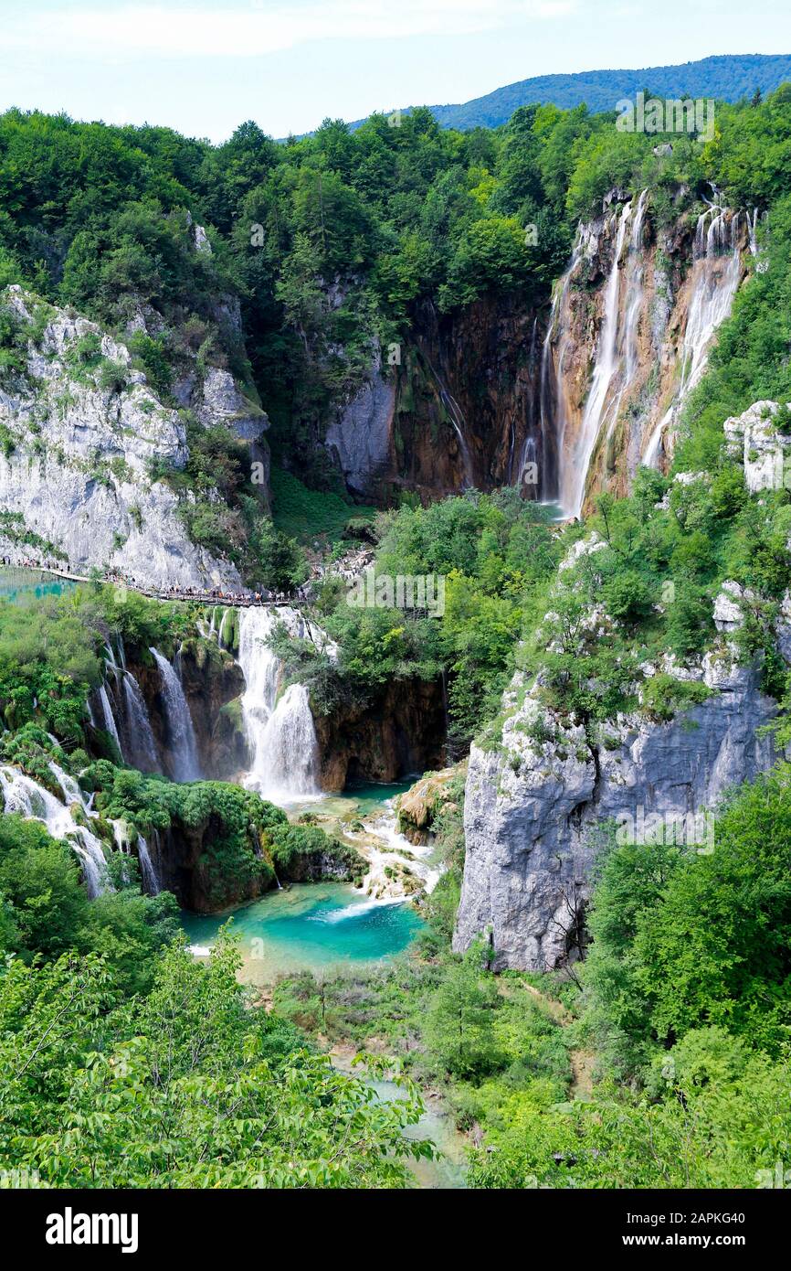I turisti esplorano le passerelle in legno intorno a Veliki Slap, la cascata più alta del Parco Nazionale dei Laghi di Plitvice in Croazia Foto Stock
