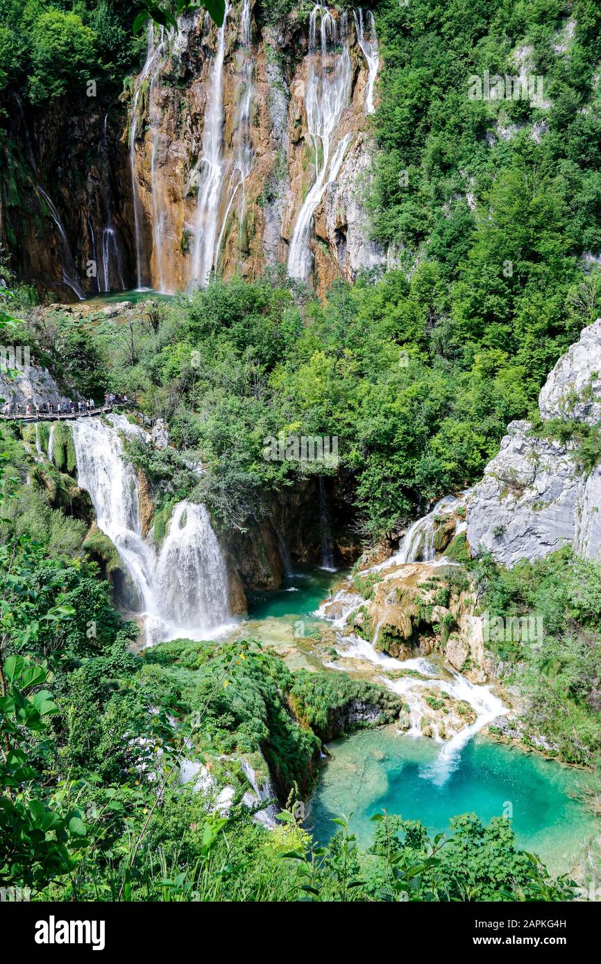 I turisti esplorano le passerelle in legno intorno a Veliki Slap, la cascata più alta del Parco Nazionale dei Laghi di Plitvice in Croazia Foto Stock