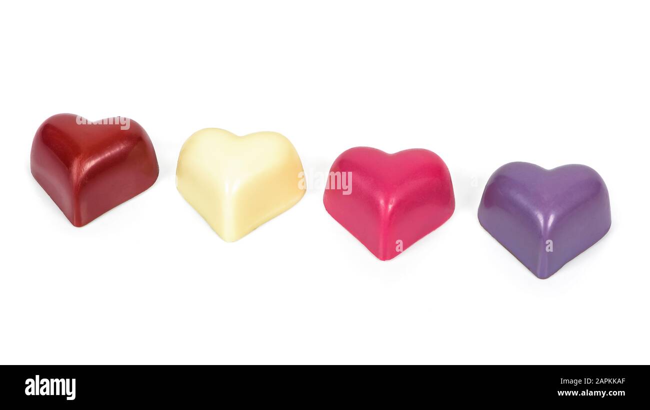 Cioccolatini colorati a forma di cuore in una fila isolata su sfondo bianco con sentiero di ritaglio Foto Stock