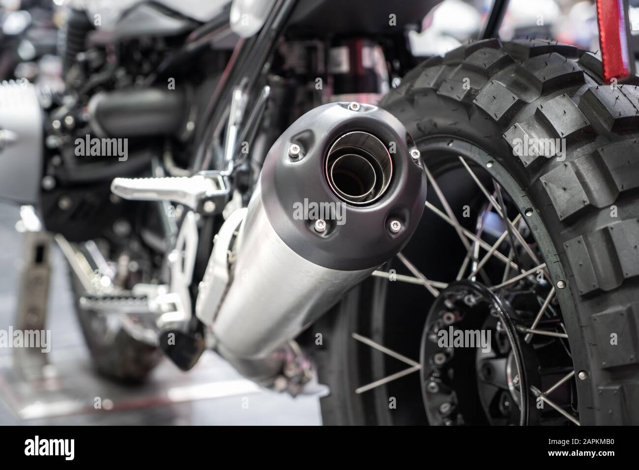 Close-up di scarico o di aspirazione di nero sport moto racing con il nuovo pneumatico e ruota in showroom. Angolo basso Fotografia della motocicletta. Foto Stock