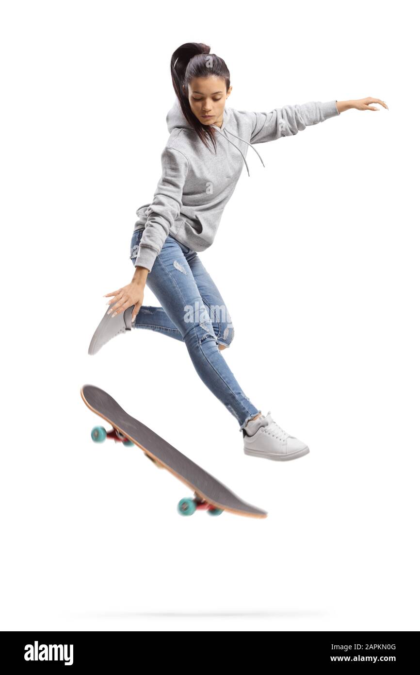 Ragazza in una felpa con cappuccio che salta con uno skateboard isolato su sfondo bianco Foto Stock