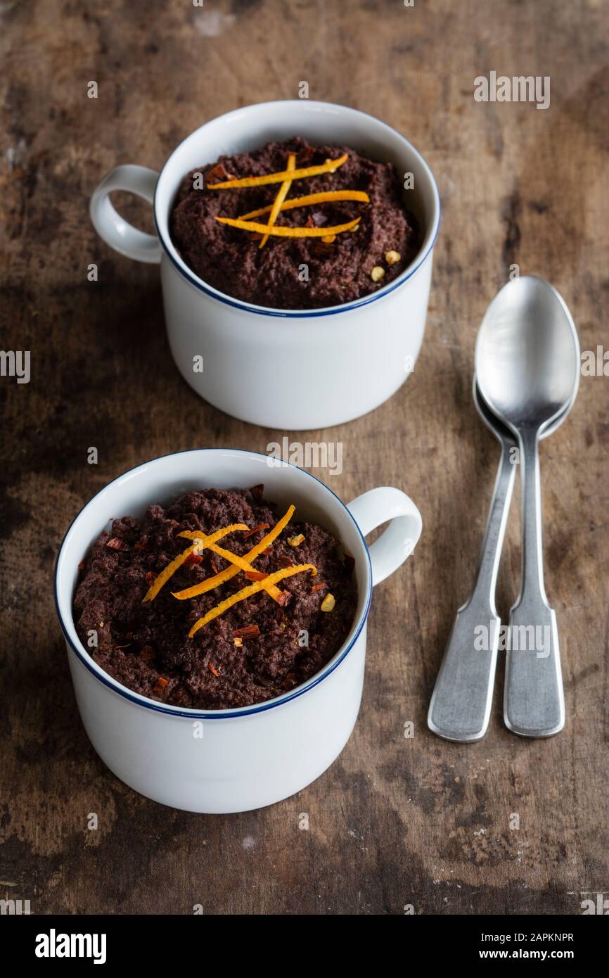 Tazze di budini di cioccolato senza glutine e lattosio con canihua, peperoncino e arancia Foto Stock