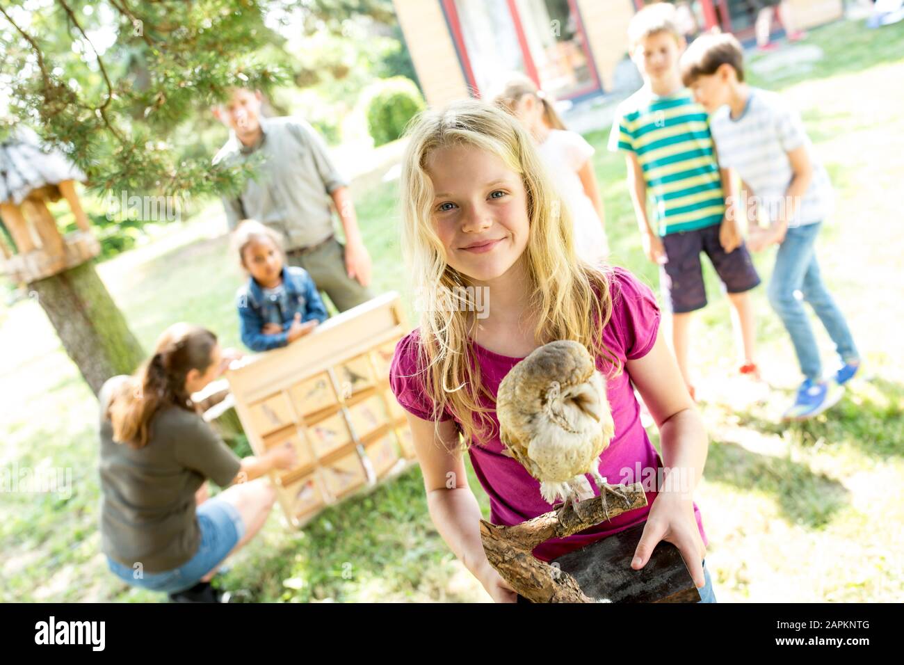 I bambini della scuola che imparano circa la specie dell'uccello, la ragazza che tiene il gufo tassodermised Foto Stock