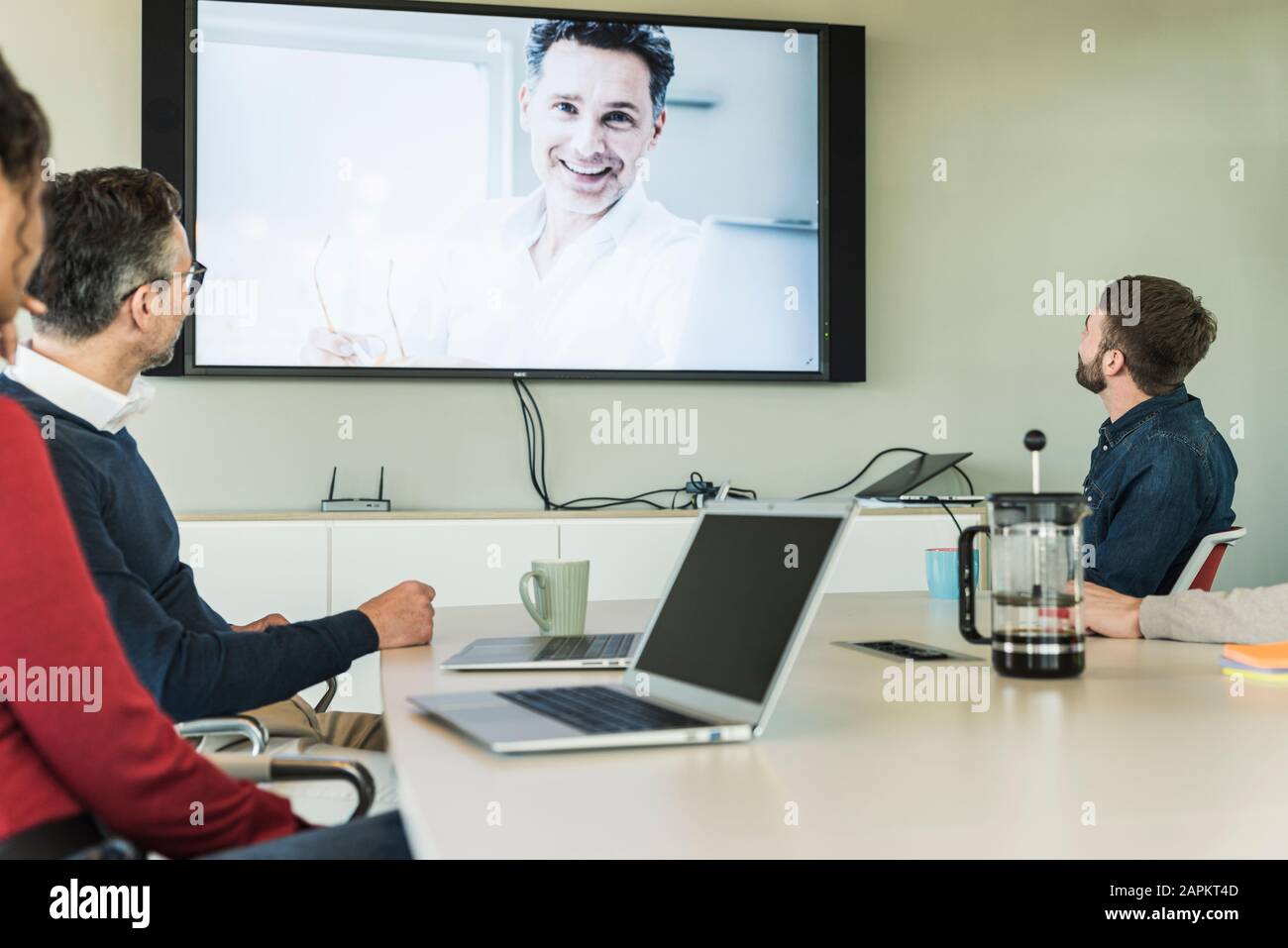Le persone in viaggio d'affari hanno una videoconferenza in sala riunioni Foto Stock