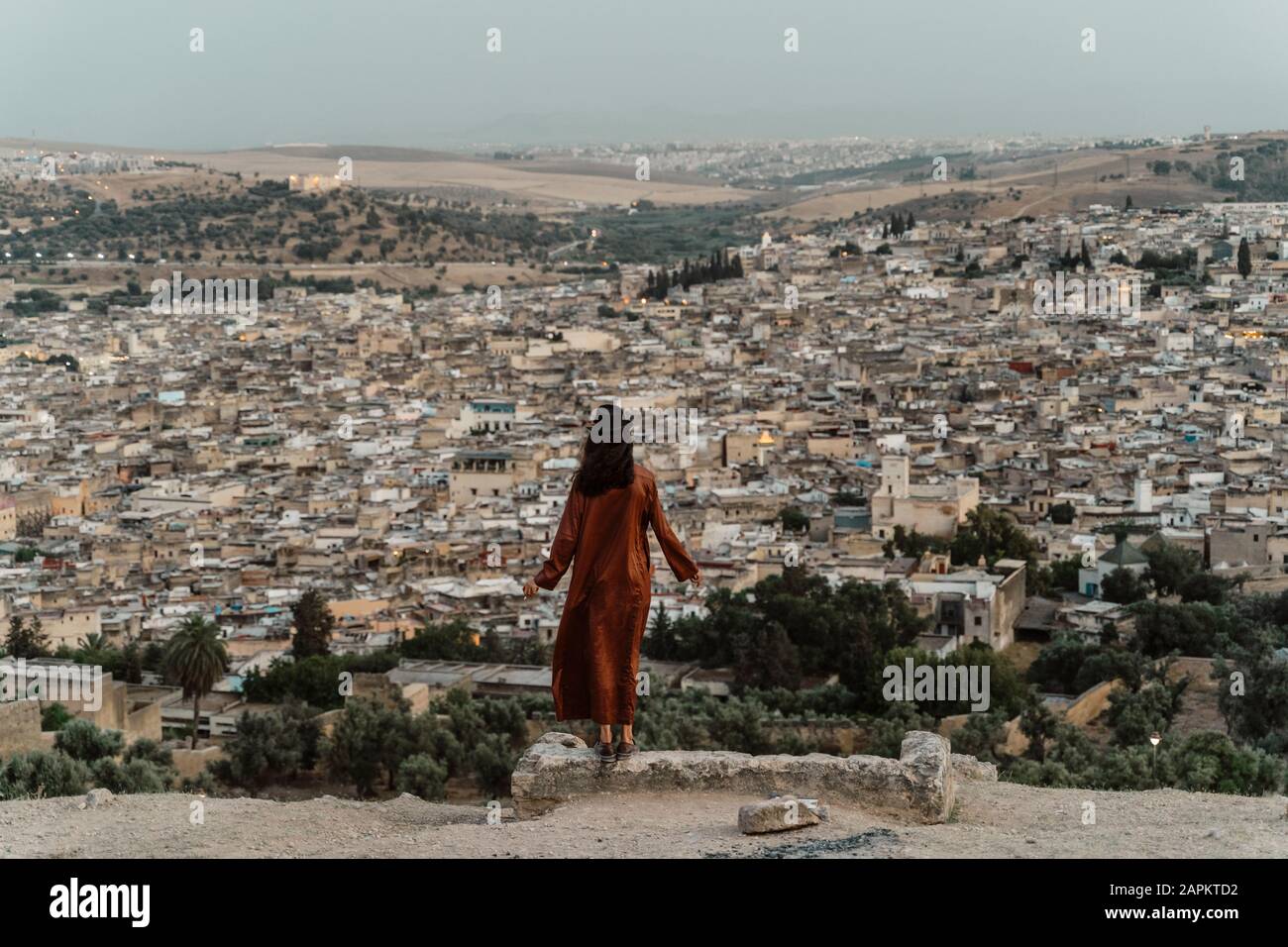 Vista posteriore della donna che gode di vista sulla città in serata, Fez, Marocco Foto Stock