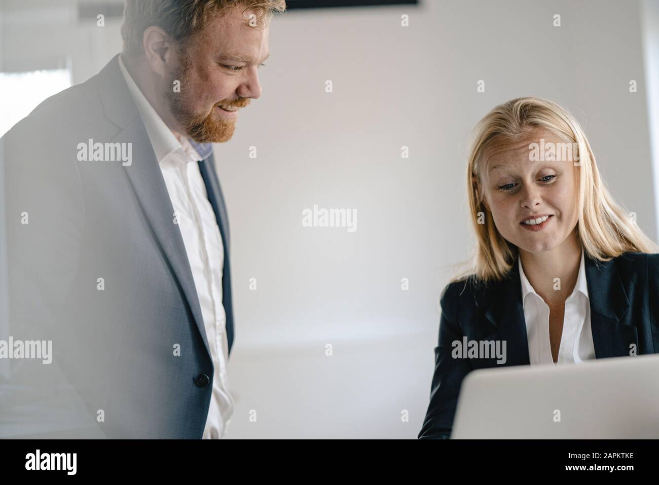 Imprenditore e imprenditrice utilizzando computer portatile in ufficio Foto Stock