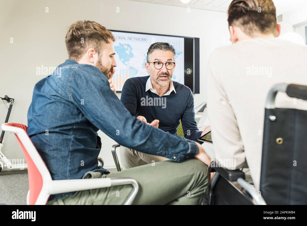 Tre uomini d'affari che hanno una riunione in ufficio Foto Stock