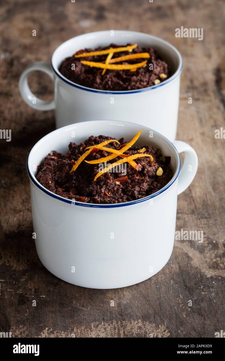 Tazze di budini di cioccolato senza glutine e lattosio con canihua, peperoncino e arancia Foto Stock