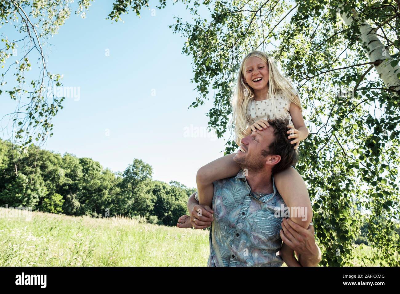 Padre Felice portando la figlia piggyback Foto Stock