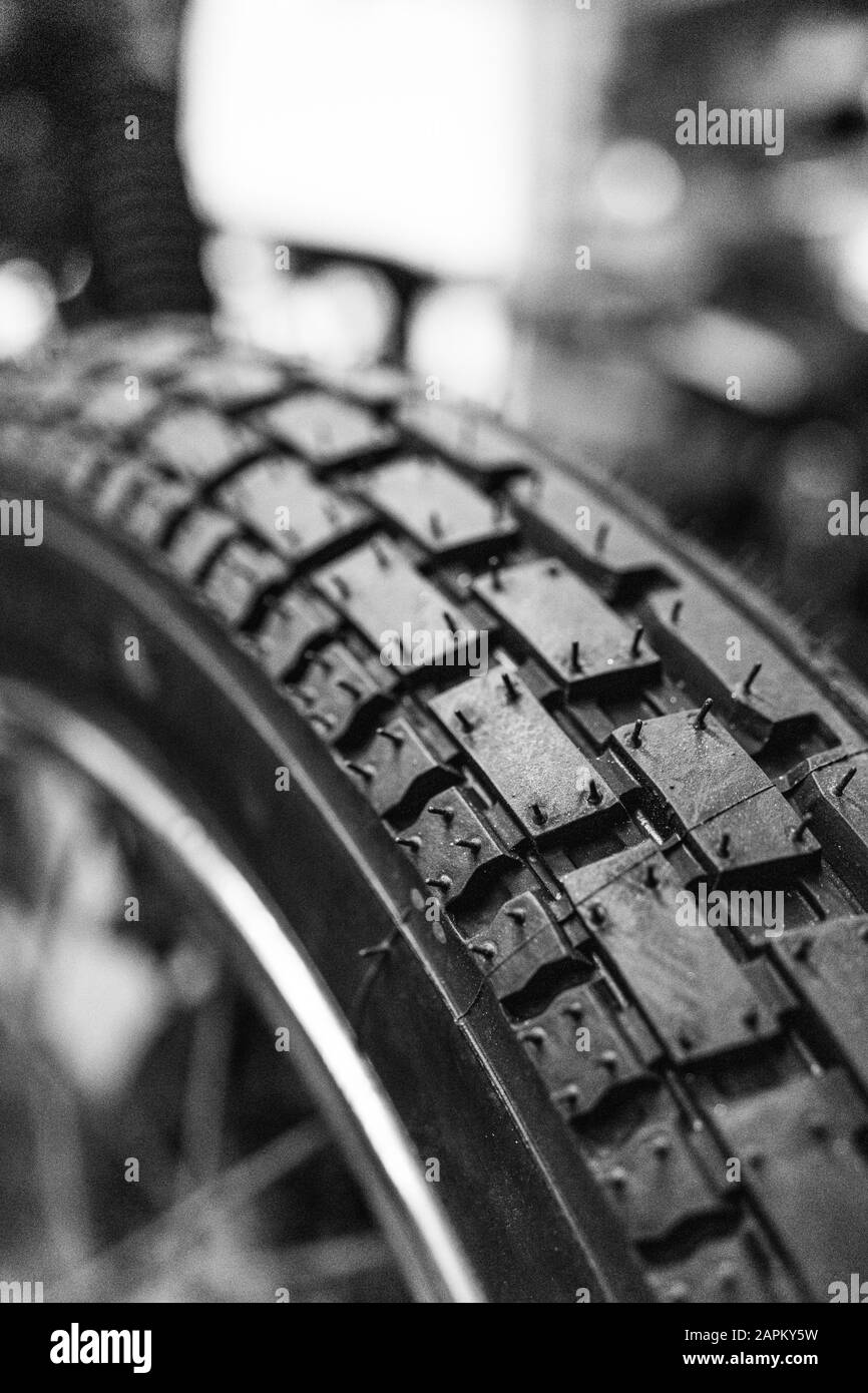Dettaglio monocromatico di un pneumatico per moto in un garage Foto Stock