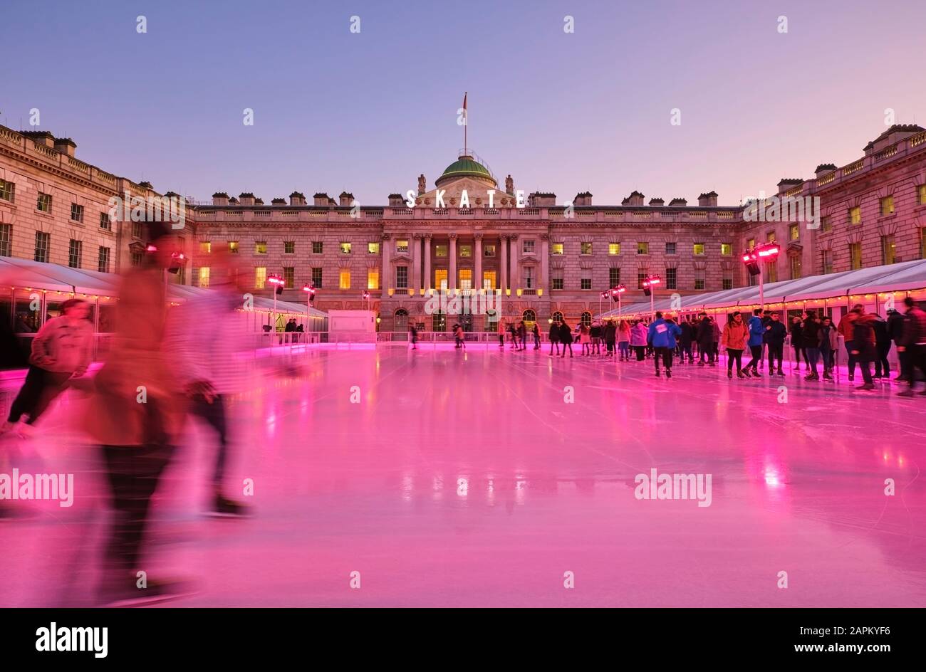 UK, Inghilterra, Londra, persone pattinaggio su ghiaccio in pista di ghiaccio rossa di fronte a Somerset House Foto Stock